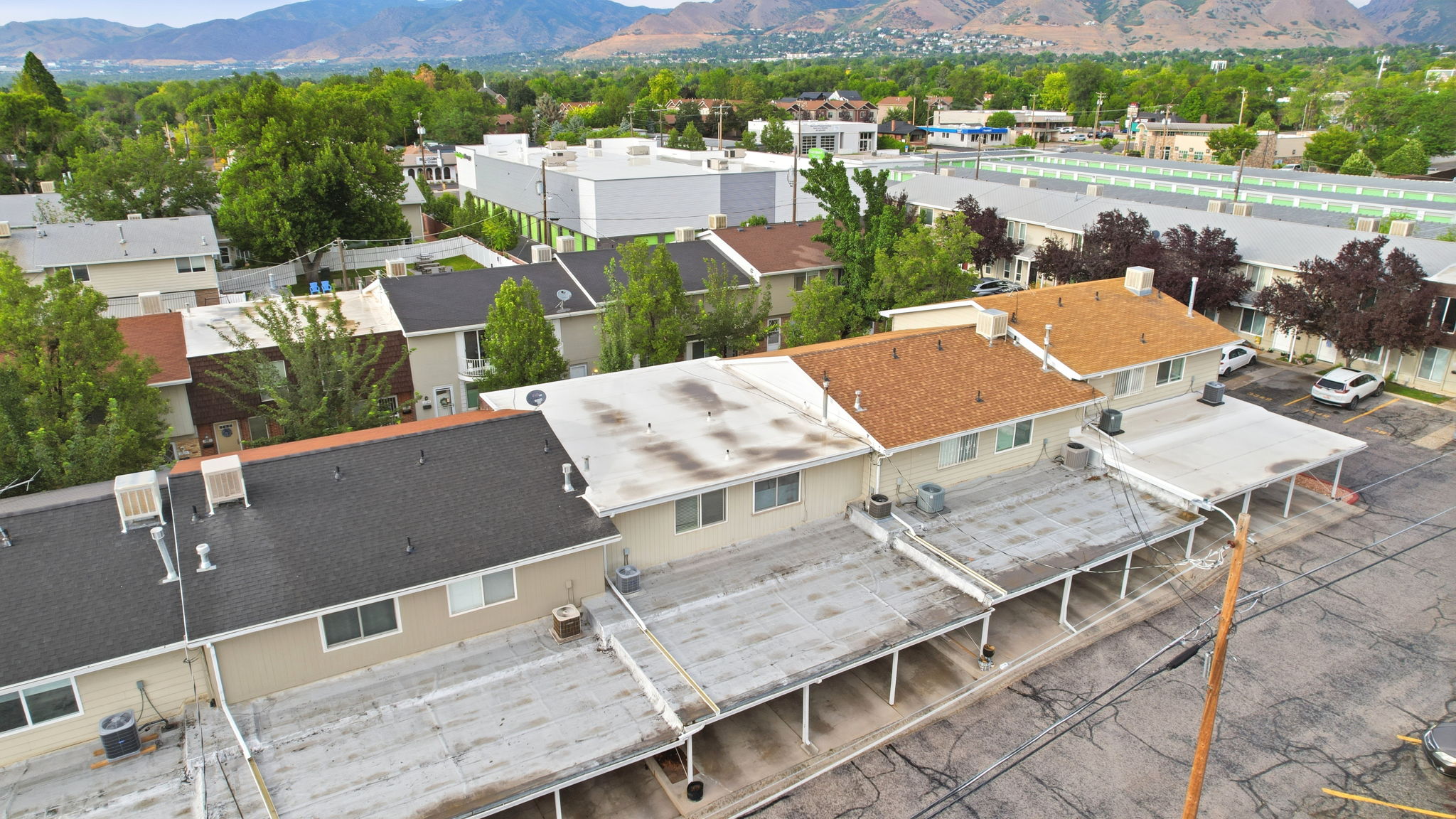 Multi-unit residential complex featuring multiple buildings with varied roofing materials including dark shingle and light flat roofs