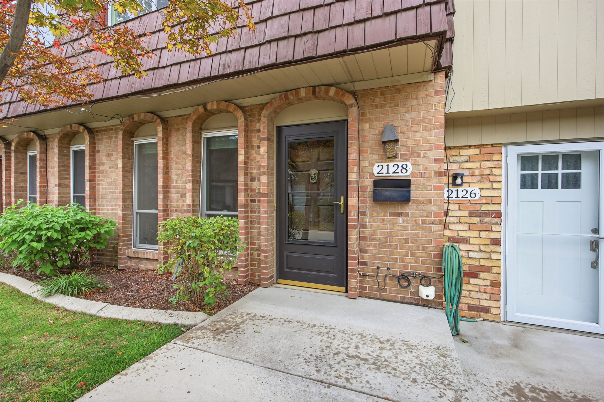 Brick exterior with arched window surrounds and a dark entry door