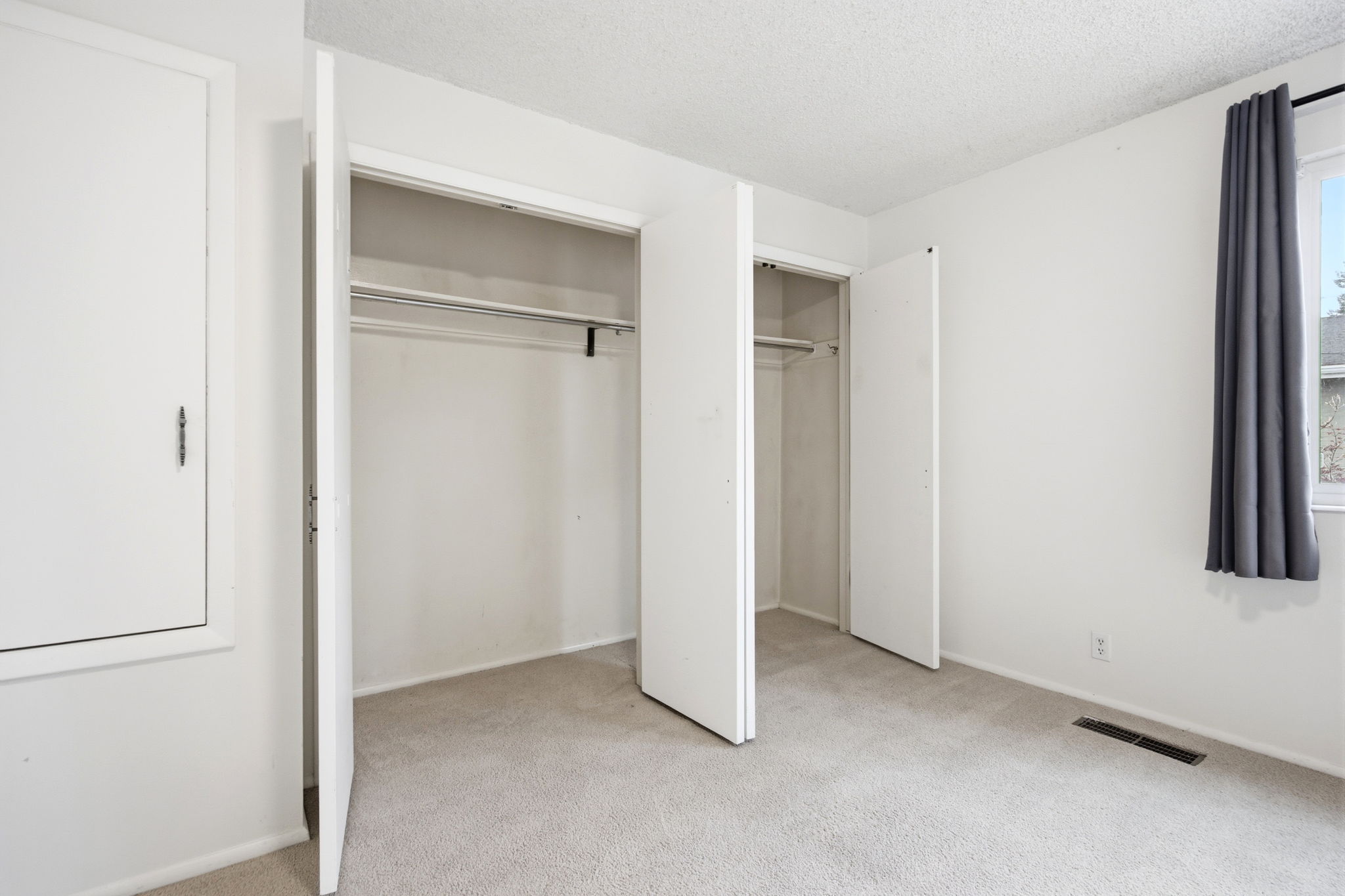 Bedroom featuring two double-door closets with hanging rods