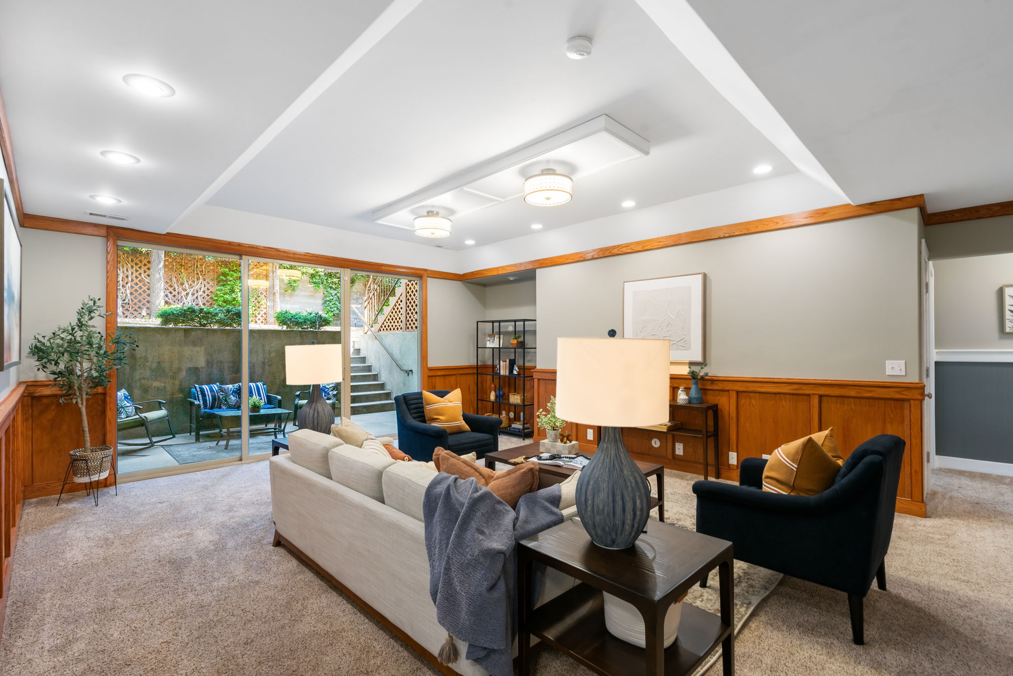 Lower level has high ceilings, the family room has architectural paneling, large sliding glass door for natural light and opens onto a covered patio for indoor outdoor living.