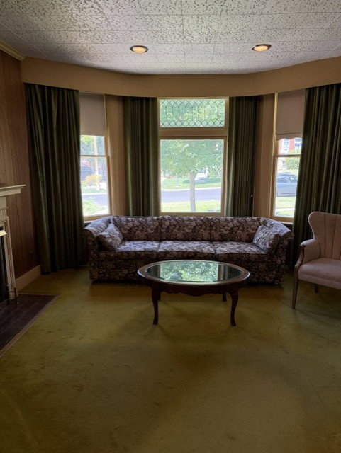 Bay window with leaded glass transom, recessed lighting, and wall-to-wall carpeting