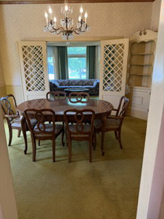 Formal dining area featuring green carpeting and a crystal chandelier