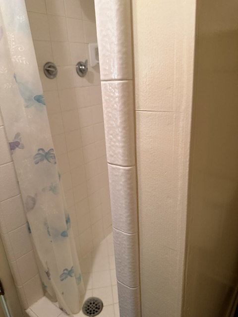 White ceramic tile shower surround with integrated soap dish