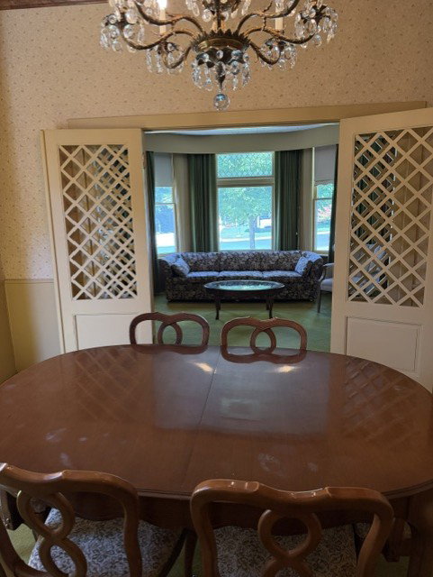 Formal dining area featuring a crystal chandelier and decorative sliding room dividers