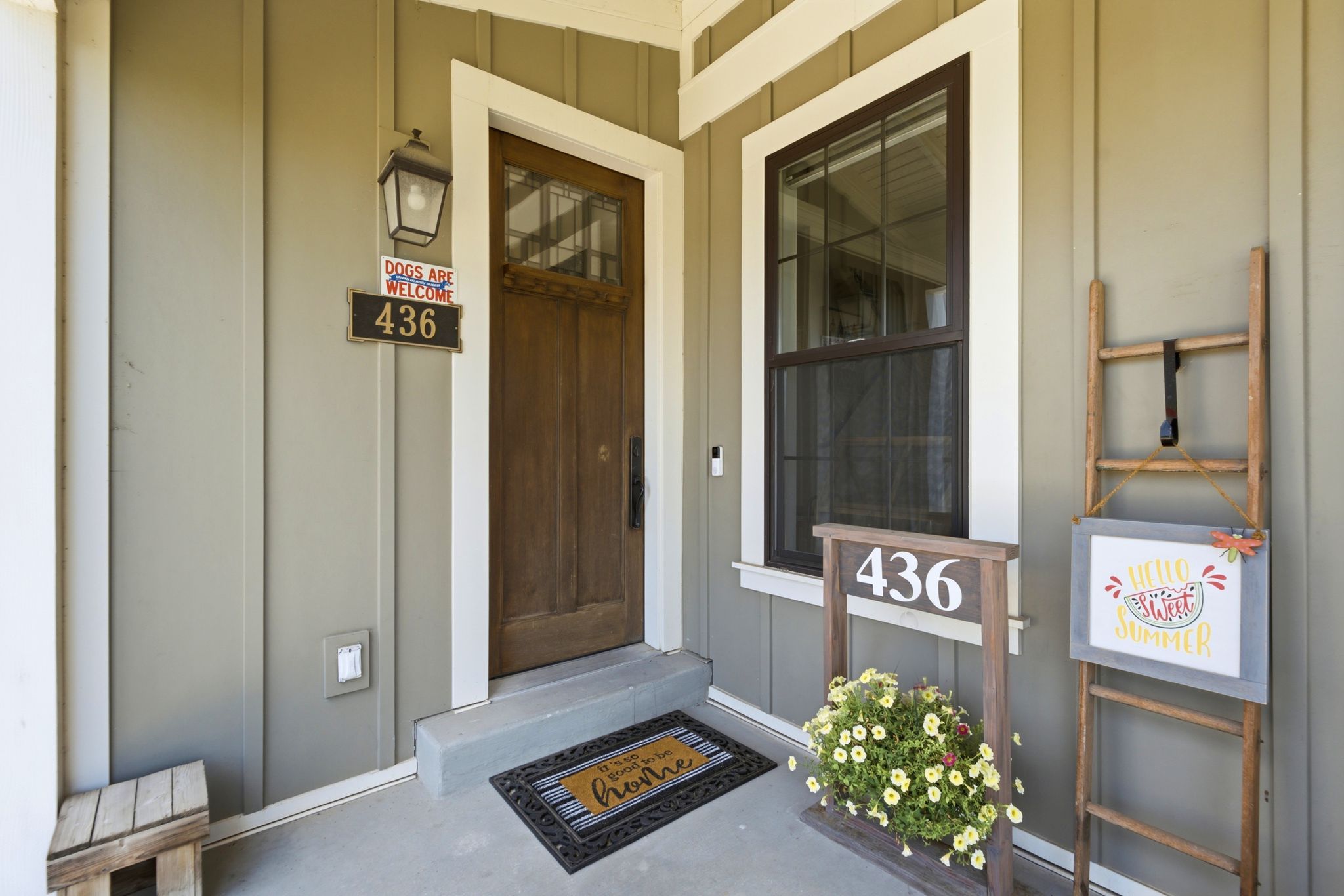 Inviting front entry featuring vertical siding, a solid wood door with upper glass panels, an exterior wall lantern