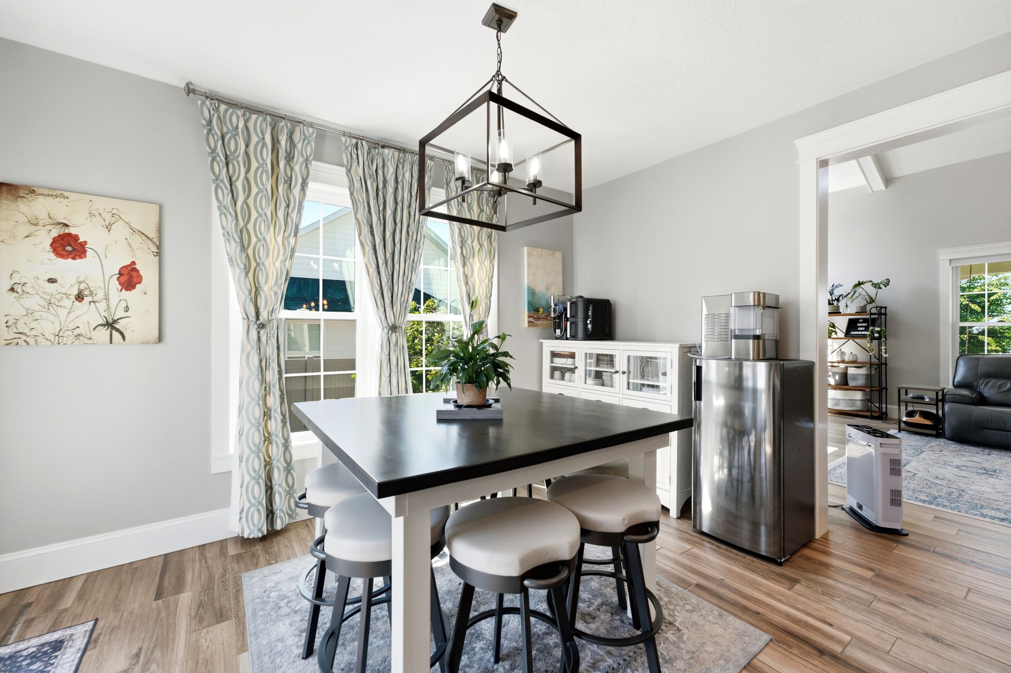Dining area featuring wood-finish flooring, a contemporary chandelier, two large windows, view of great room