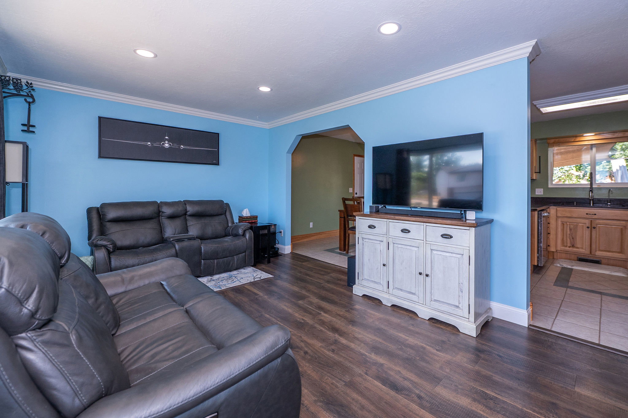 Living area featuring wood-finish flooring, recessed lighting, and crown molding