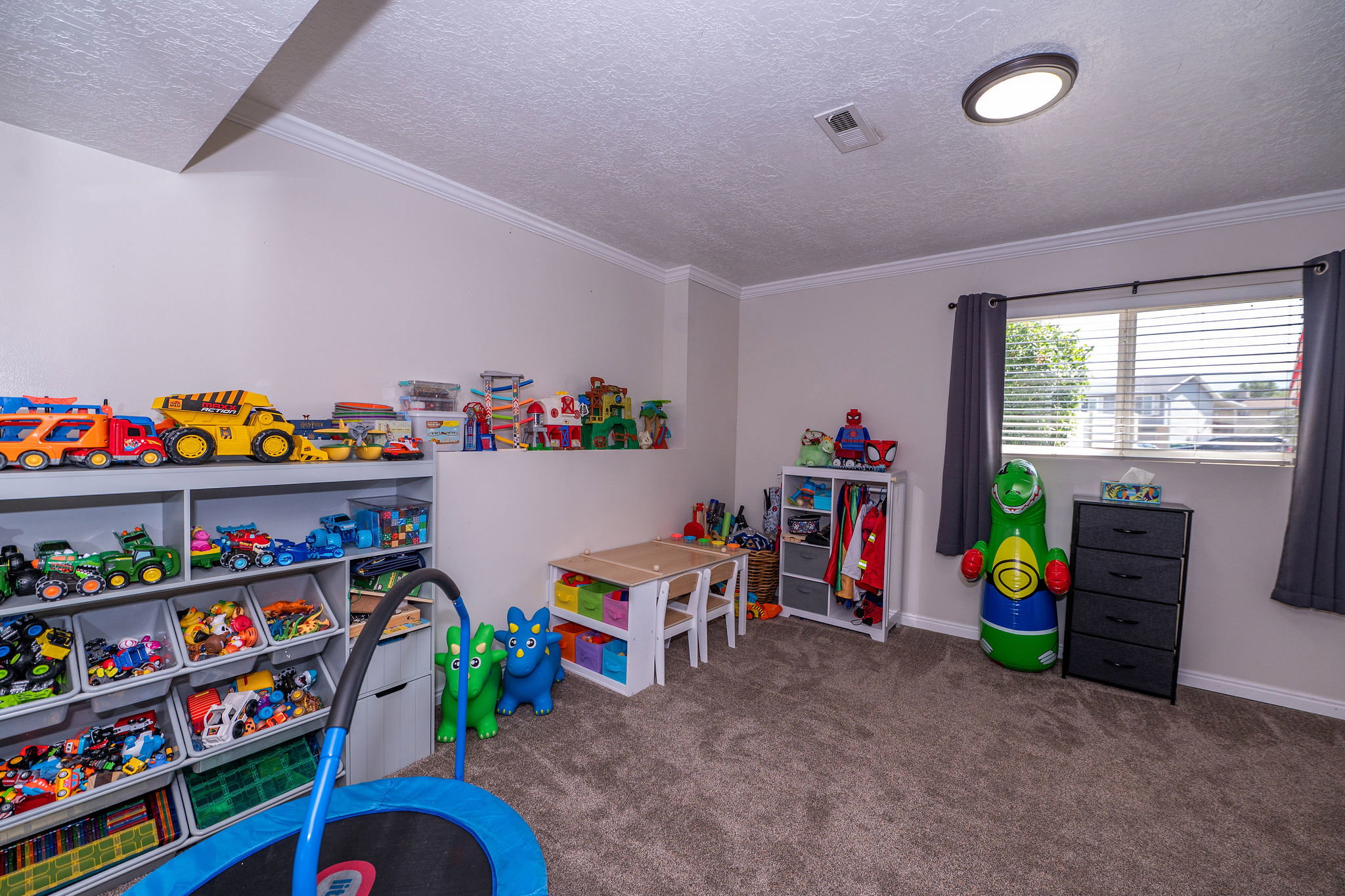 Carpeted room featuring crown molding, a window with blinds, and a flush-mount ceiling light
