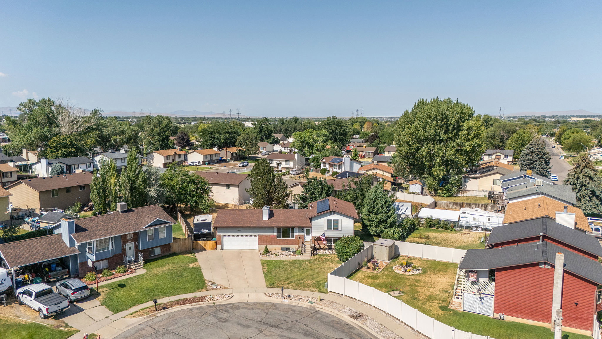 Residential neighborhood featuring multiple single-family homes, mature trees, and paved streets