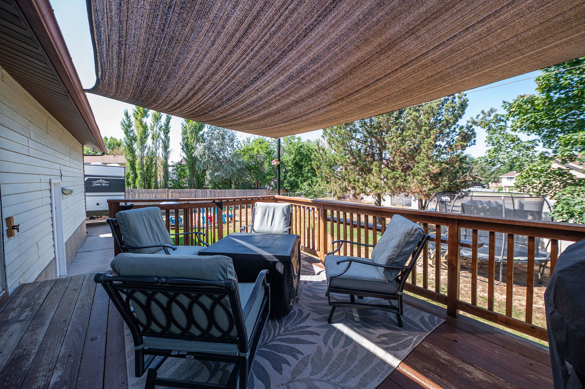 Expansive wooden deck featuring a fabric shade canopy