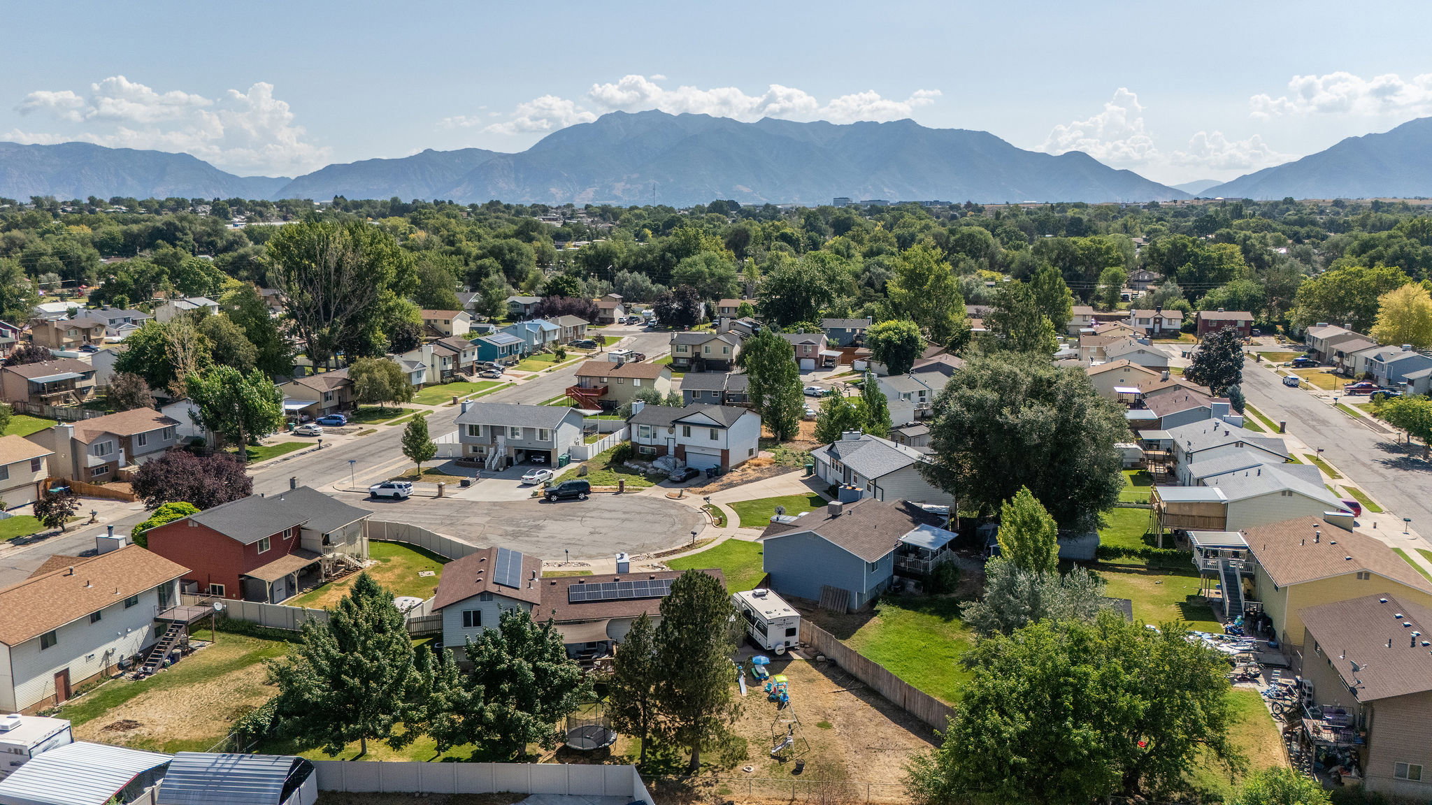 Residential neighborhood with mature trees, established streets, and mountain backdrop