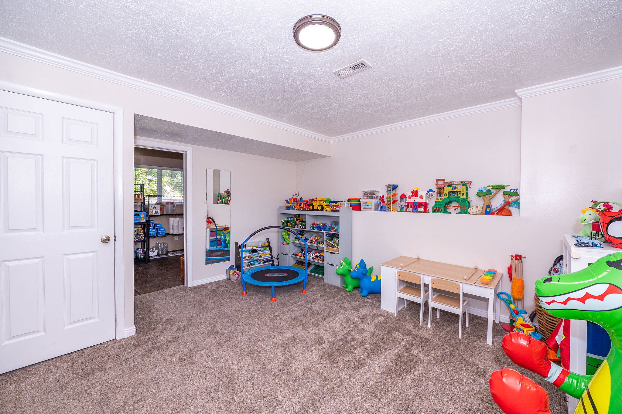 Carpeted interior space featuring white trim and crown molding