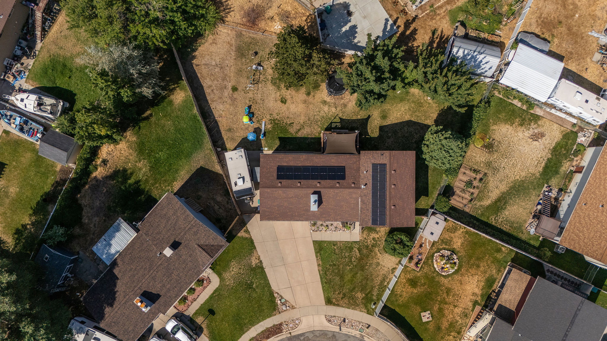 Aerial perspective showcasing the property with a brown shingle roof and integrated solar panels