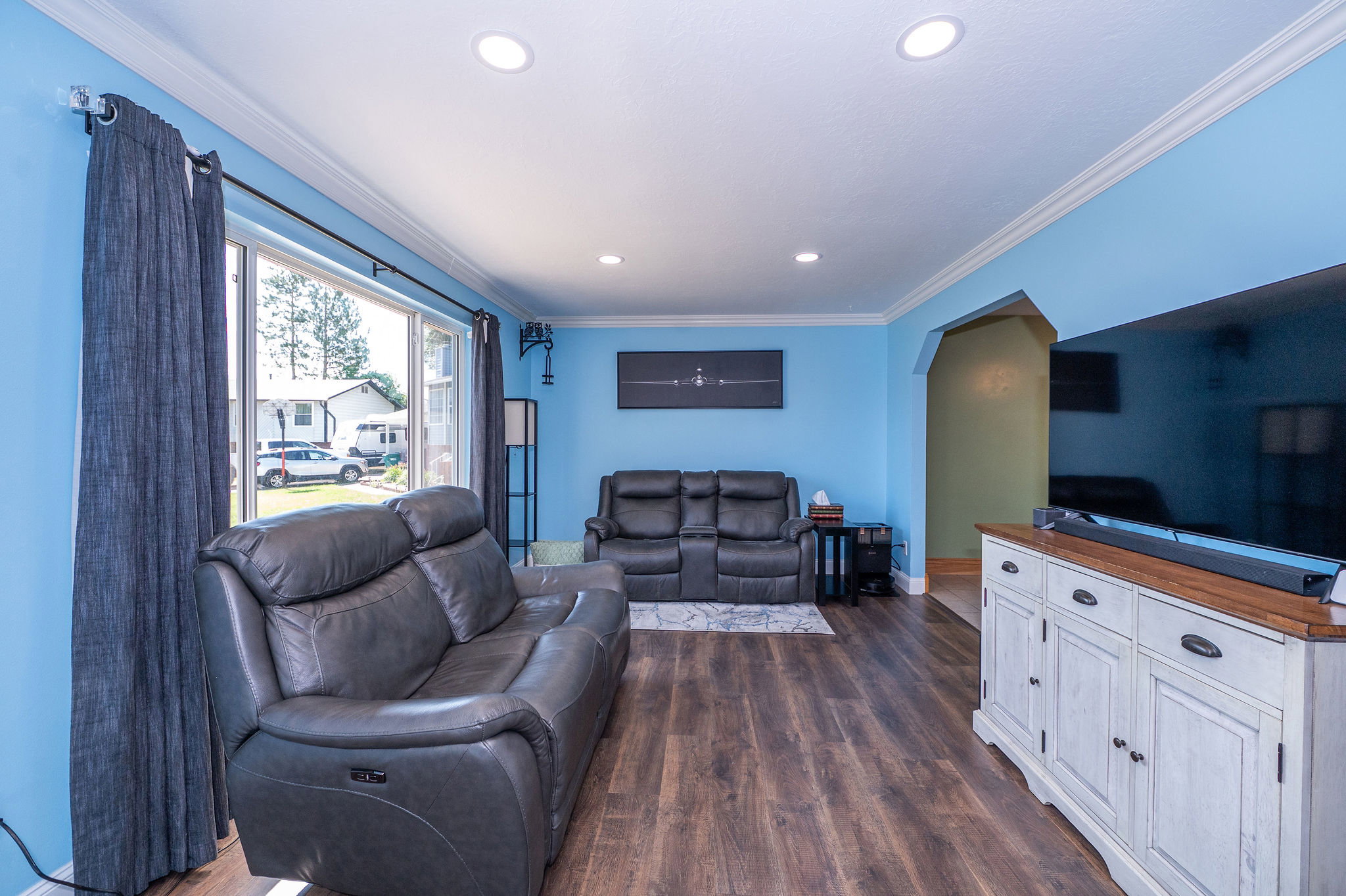 Living area featuring wood-finish flooring, recessed lighting, and crown molding