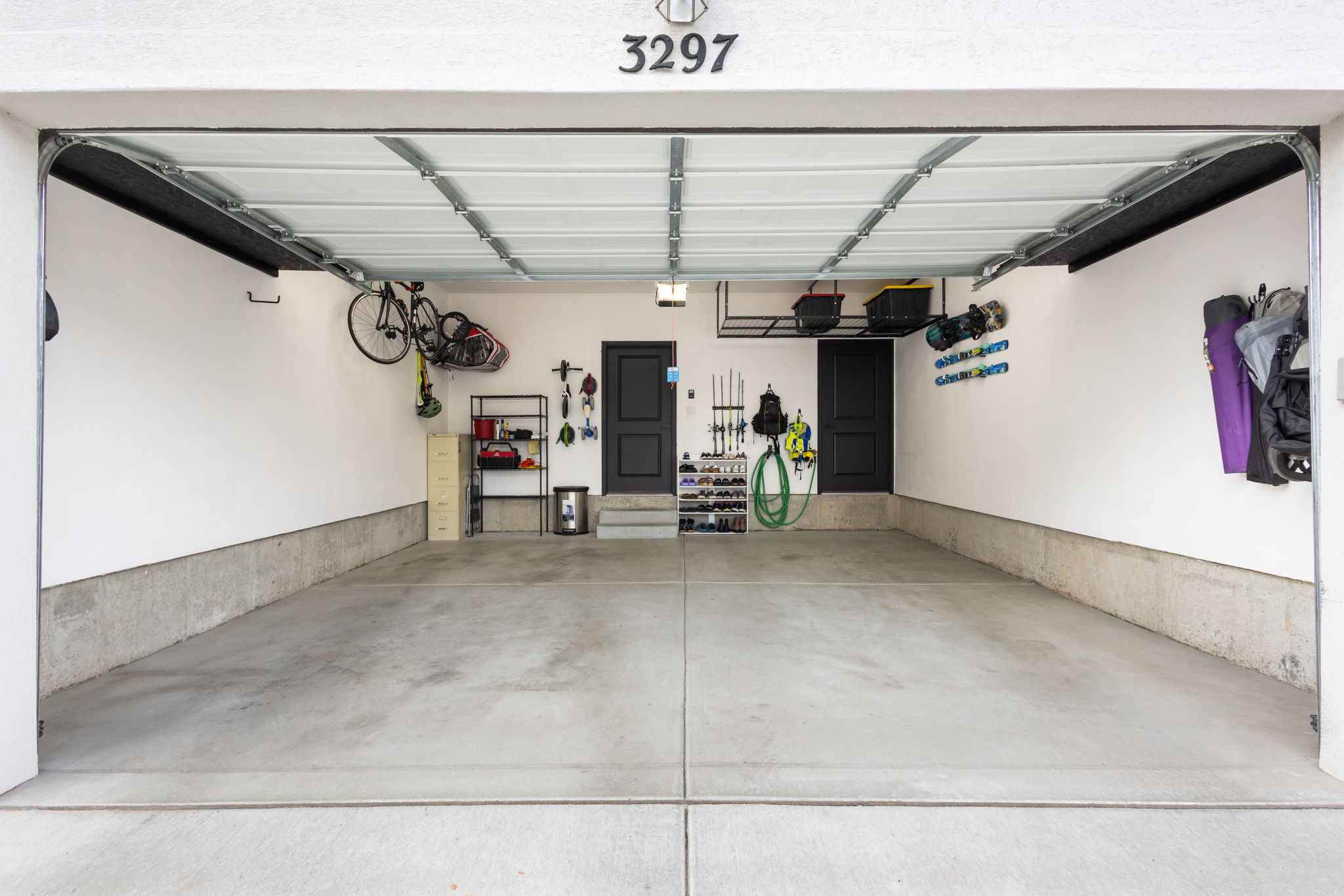 Two-car garage featuring a concrete floor, white walls, and two internal access doors