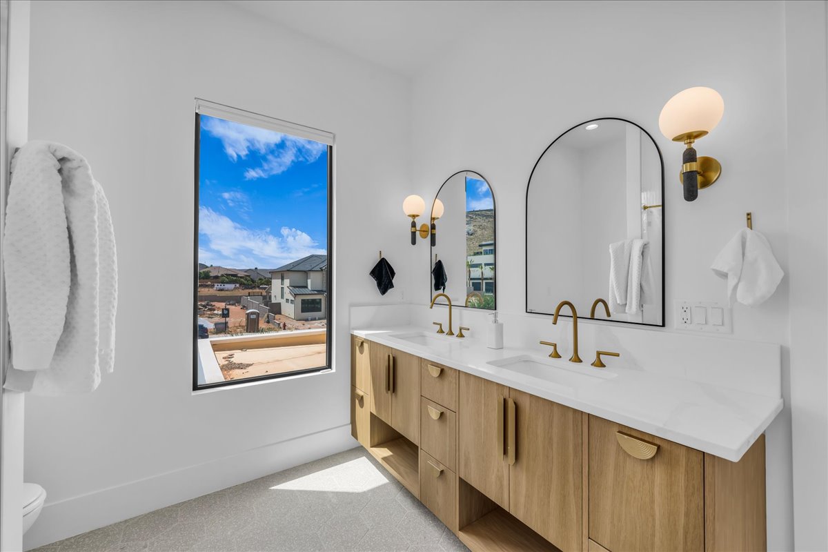 Double vanity with wood-finish cabinetry, white countertops, and integrated sinks