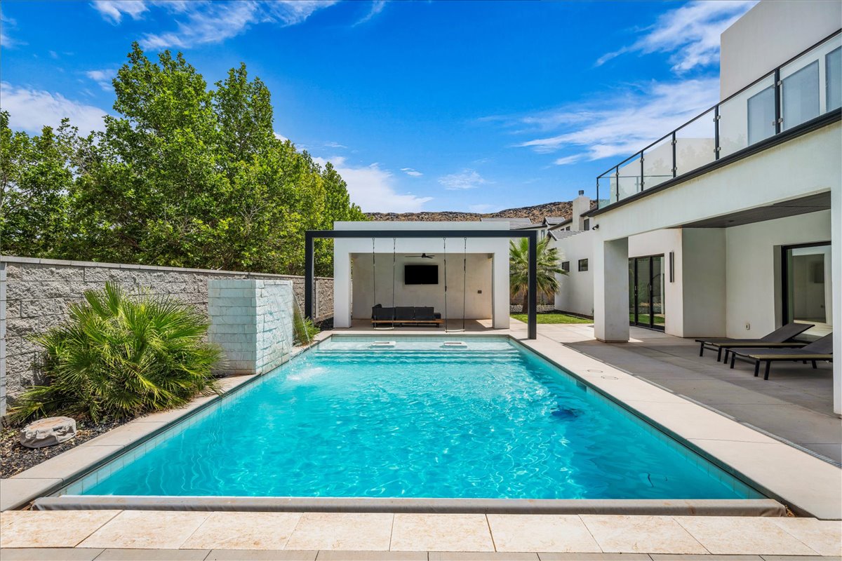Swimming pool with integrated steps, surrounded by light-toned paving stones