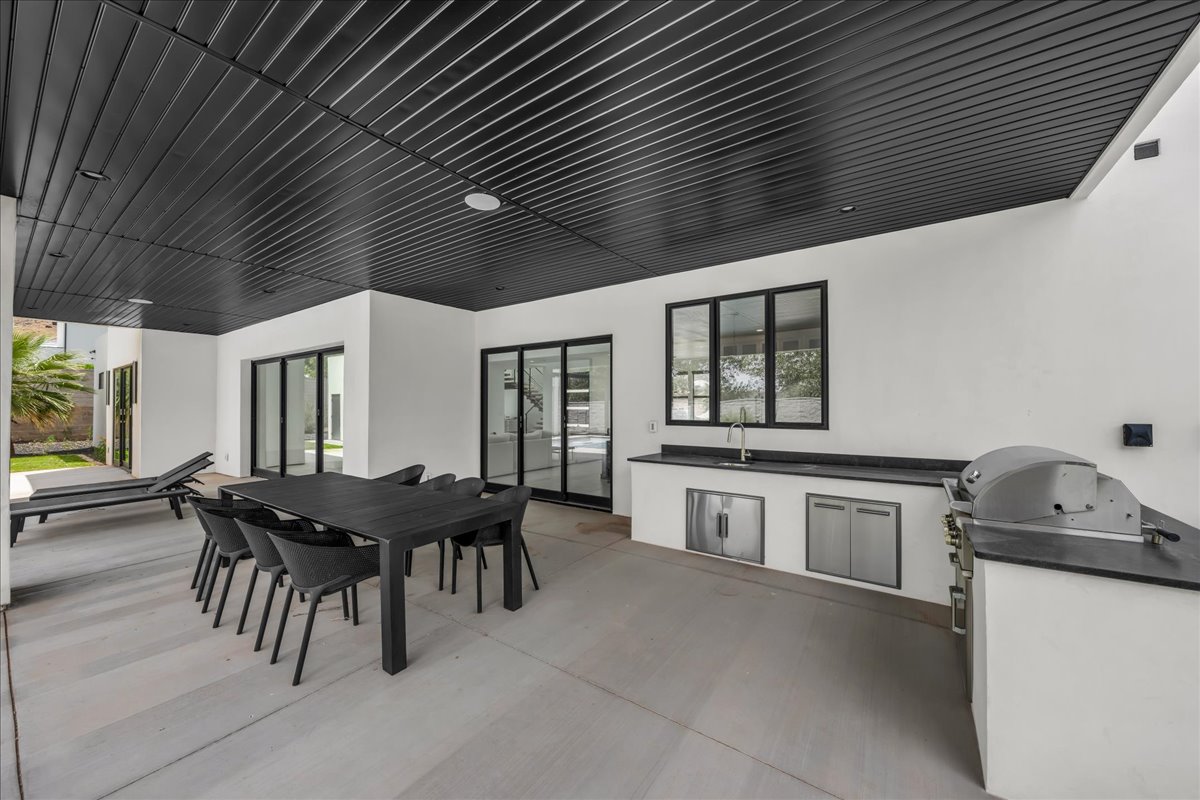 Expansive covered patio featuring a black slatted ceiling and recessed lighting