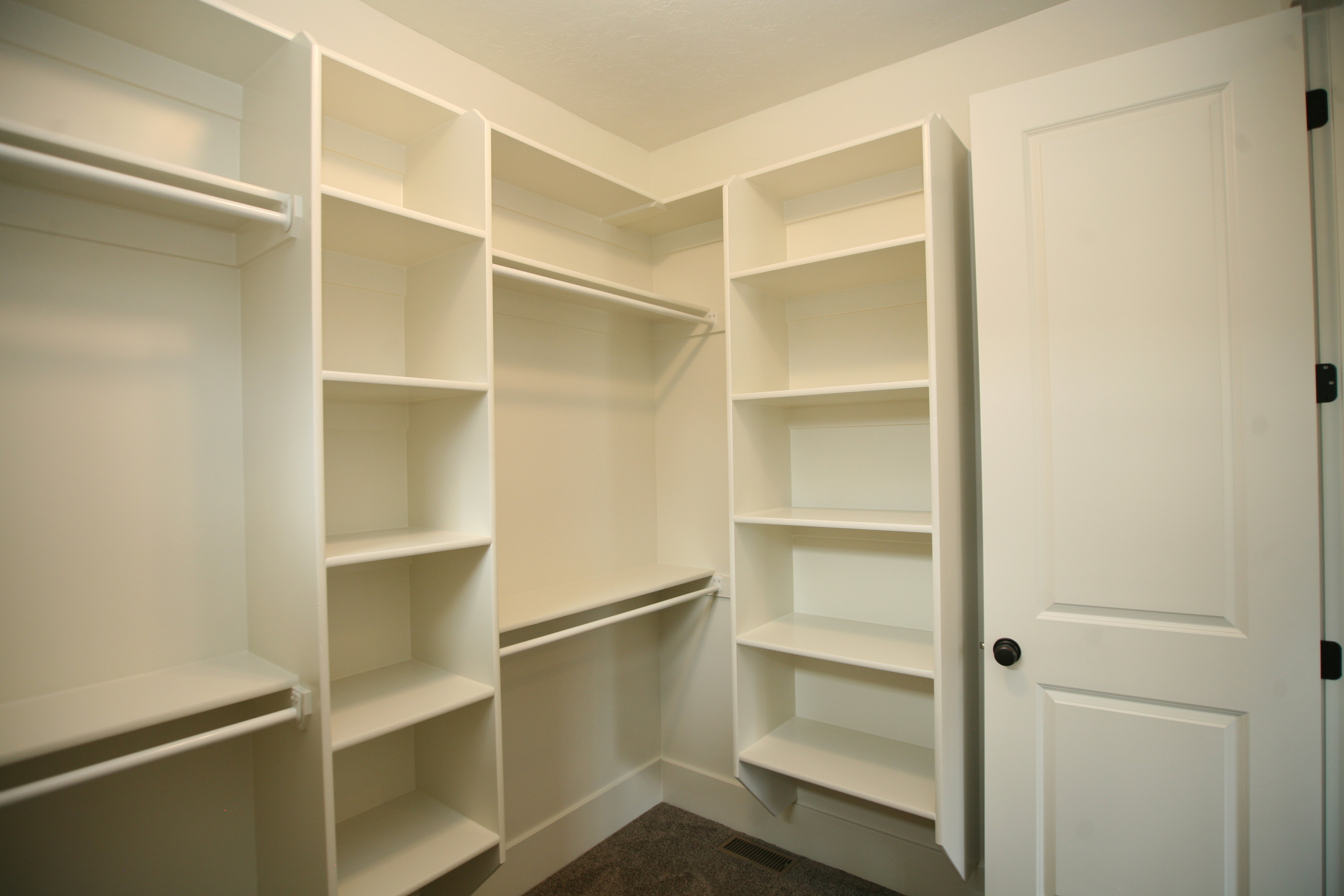 Built-in white shelving and hanging rods create a versatile closet system, this home has storage in all the closets