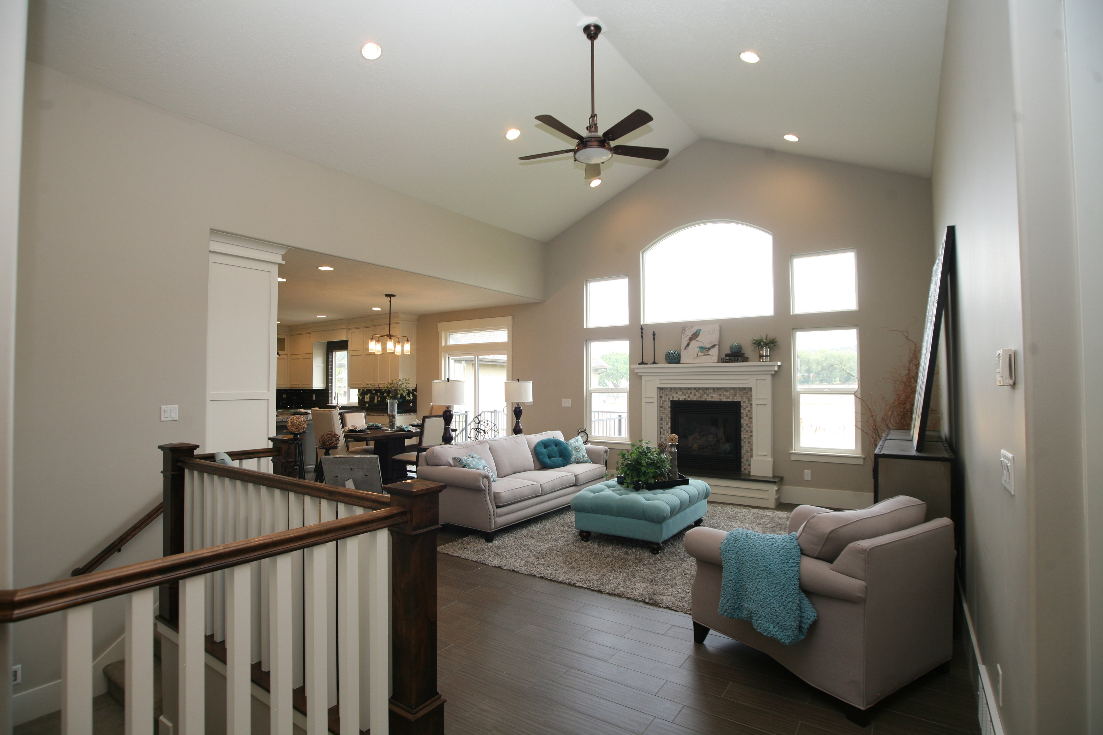 Expansive living area featuring a vaulted ceiling with a ceiling fan, recessed lighting, and wood-finish flooring