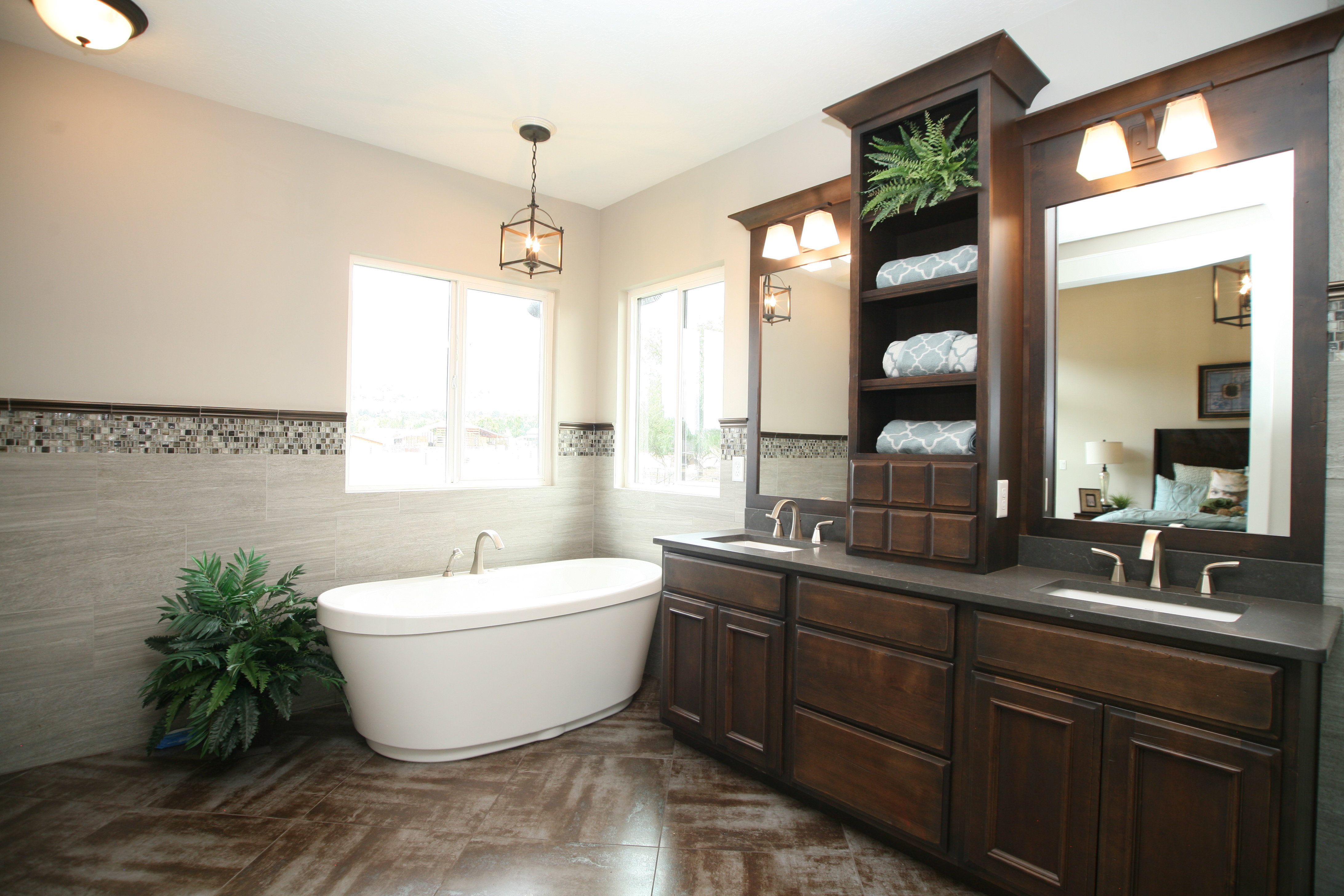 Contemporary bathroom featuring a freestanding soaking tub, wood-finish flooring, and a dual vanity with undermount sinks
