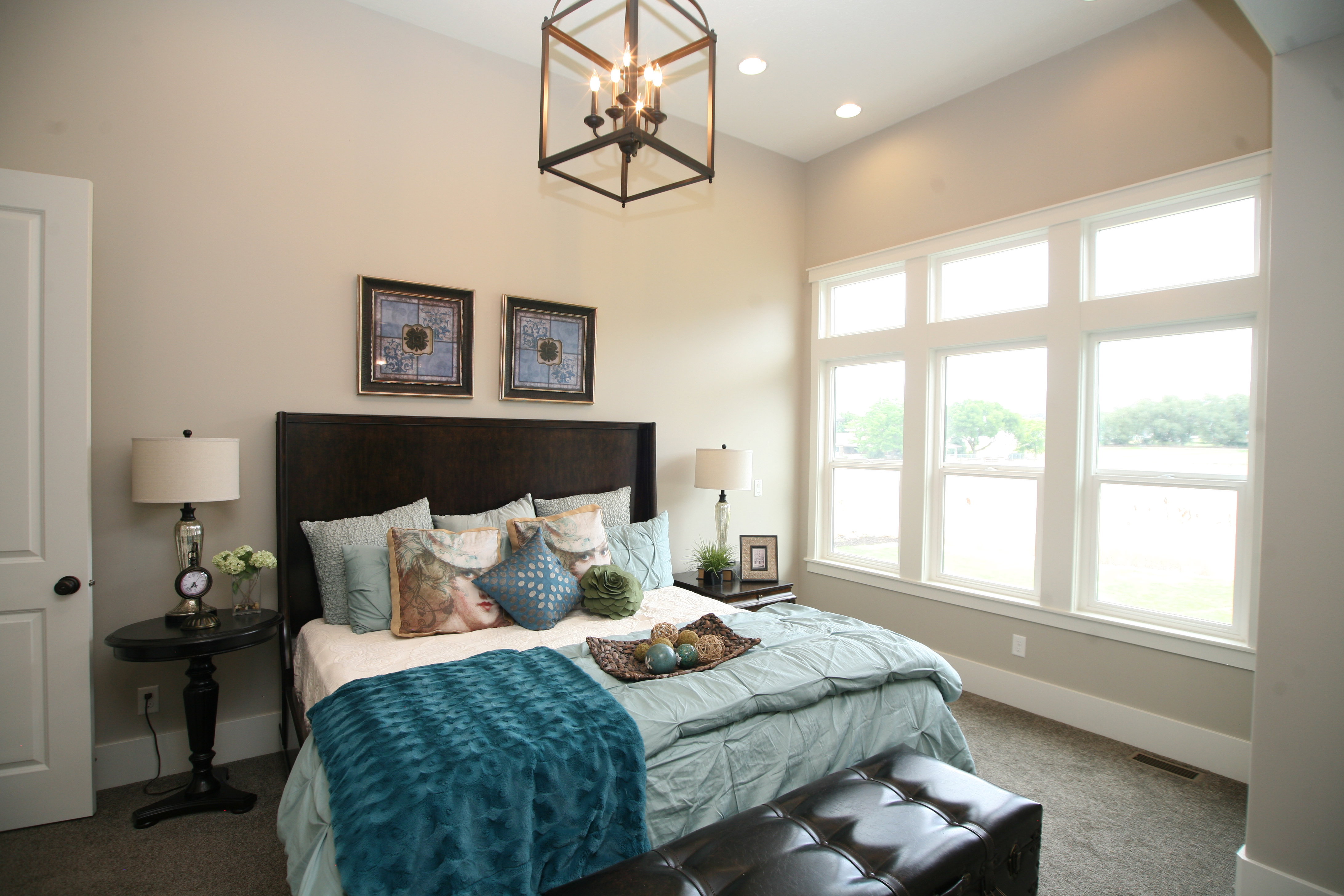 Spacious room featuring multiple large windows, recessed lighting, and a prominent open-cage chandelier