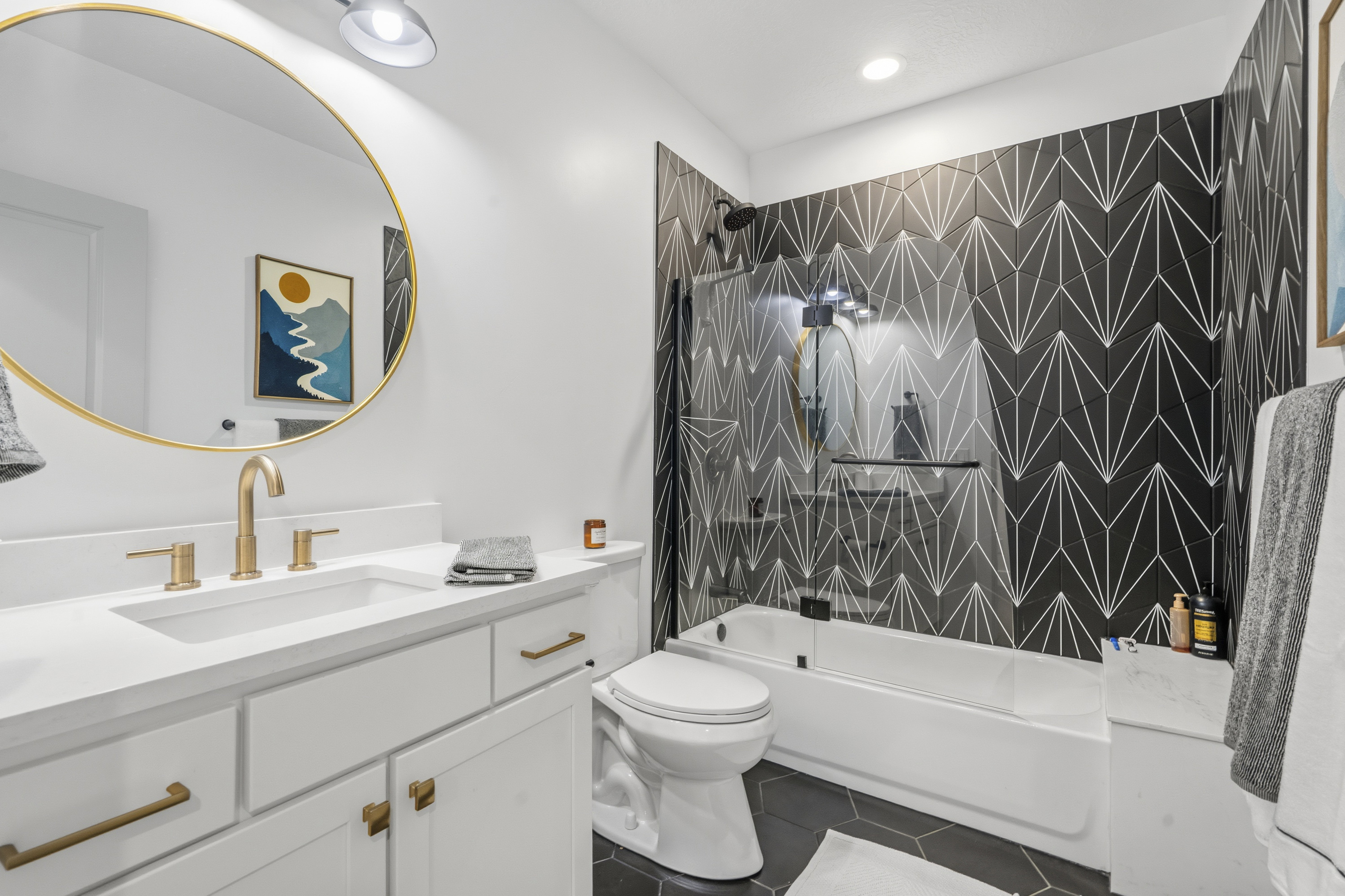 Modern bathroom featuring a white vanity with a rectangular undermount sink and brass-finish fixtures