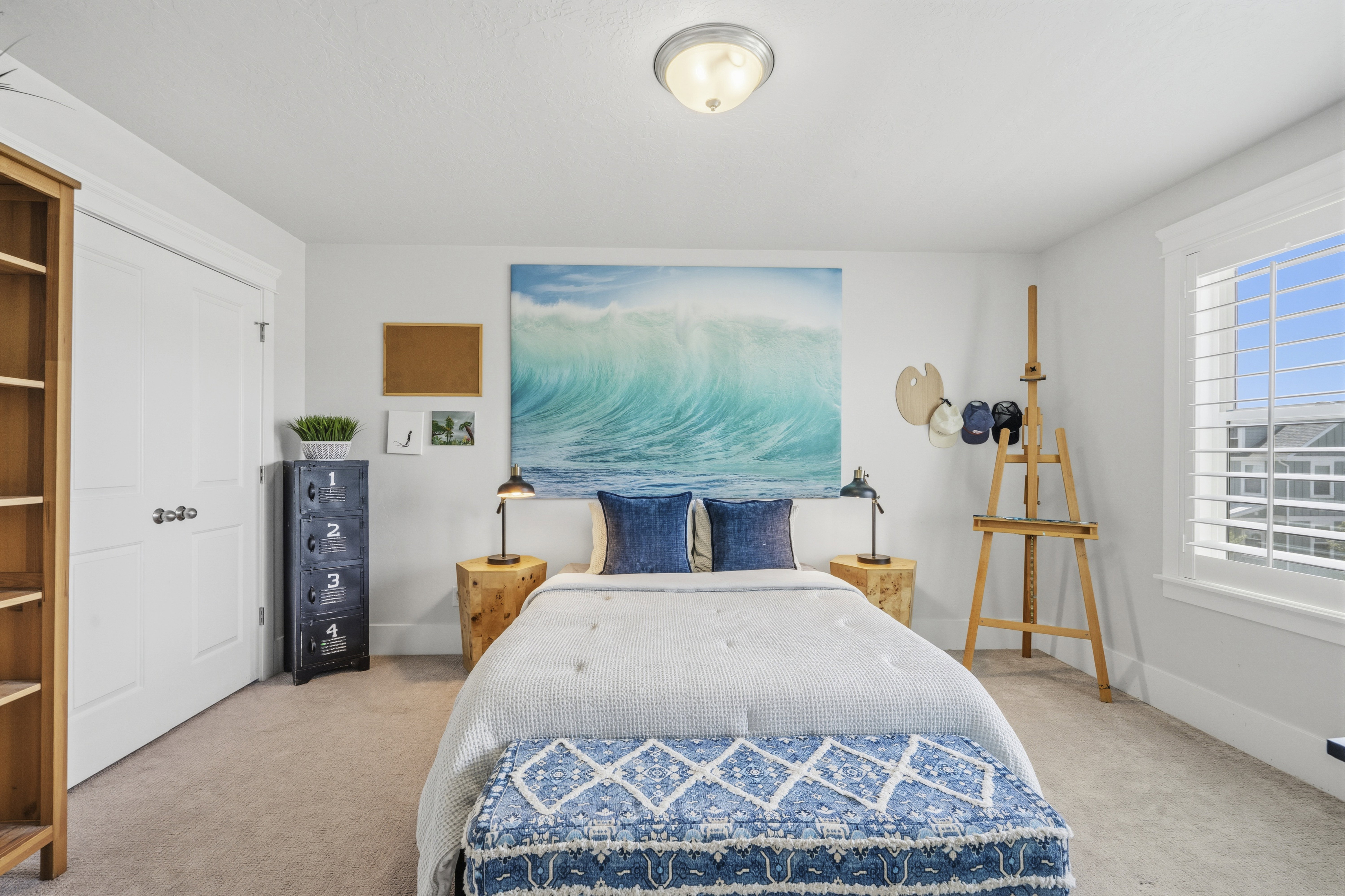 Bedroom featuring light gray walls, plush carpet flooring, a built-in closet with white bifold doors, a white window with plantation shutters, and a ceiling-mounted semi-flush light fixture