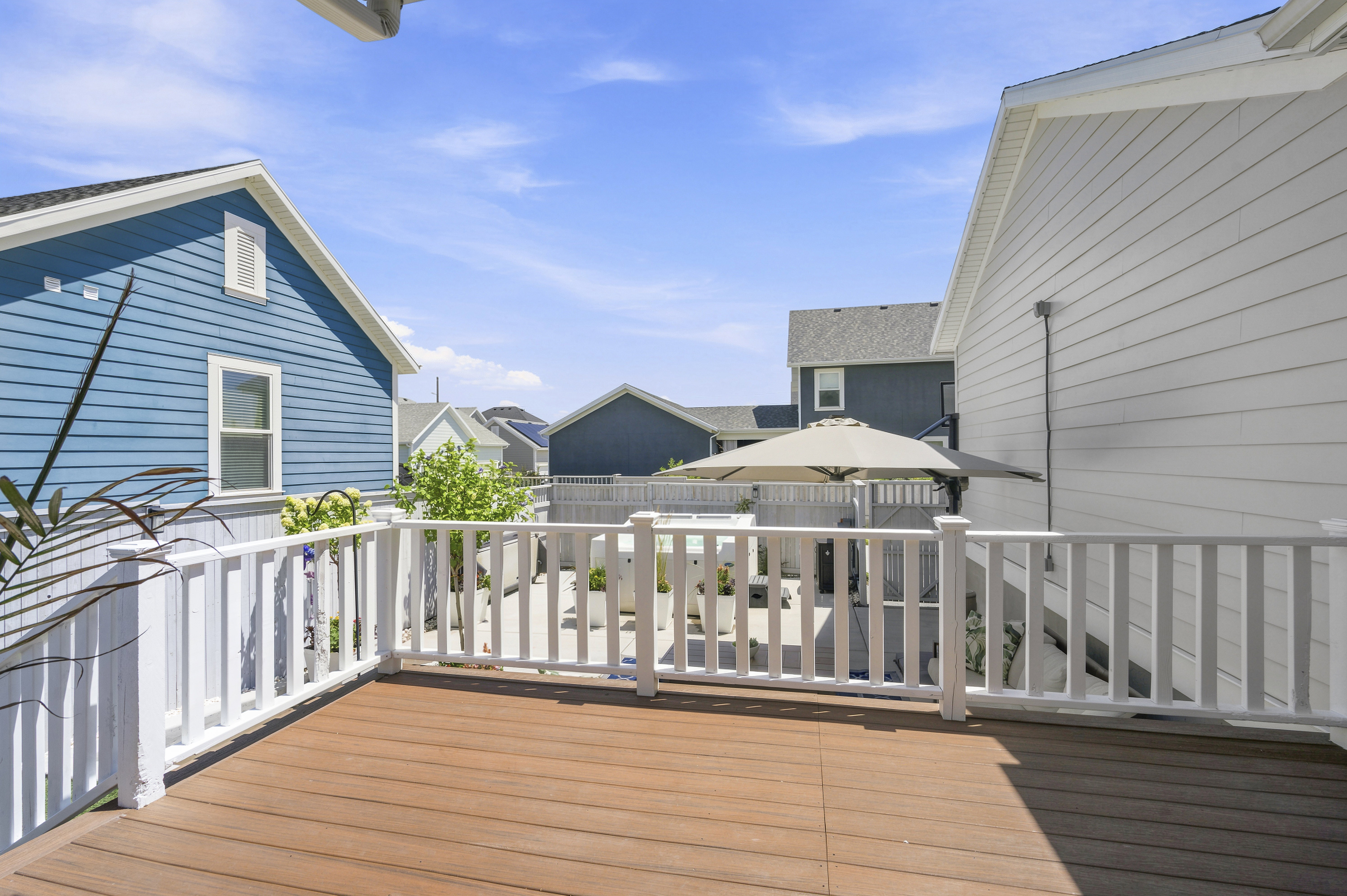 Expansive outdoor deck featuring wood-finish flooring and white perimeter railing