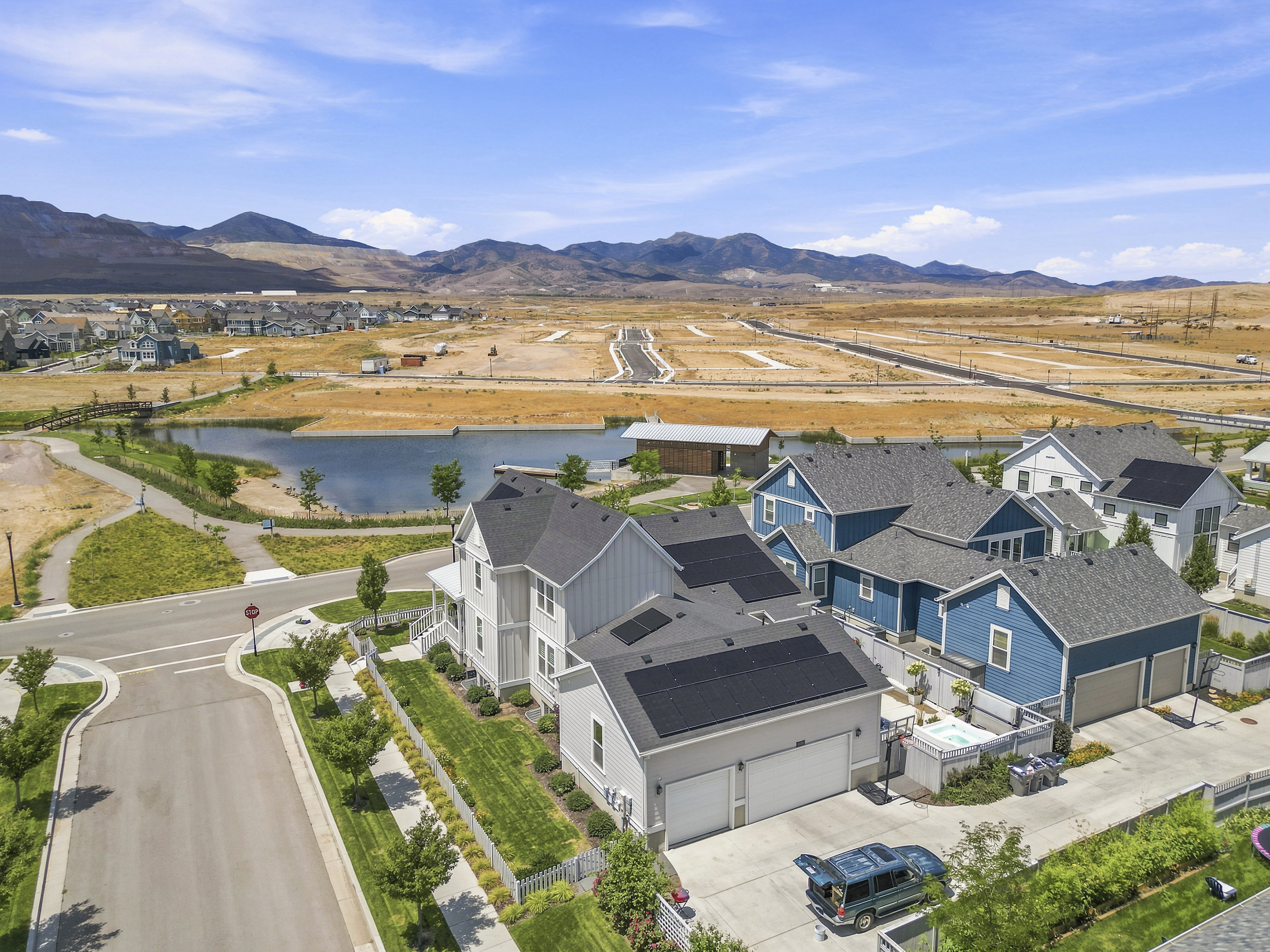 Modern residential development featuring a community lake and mountain backdrop
