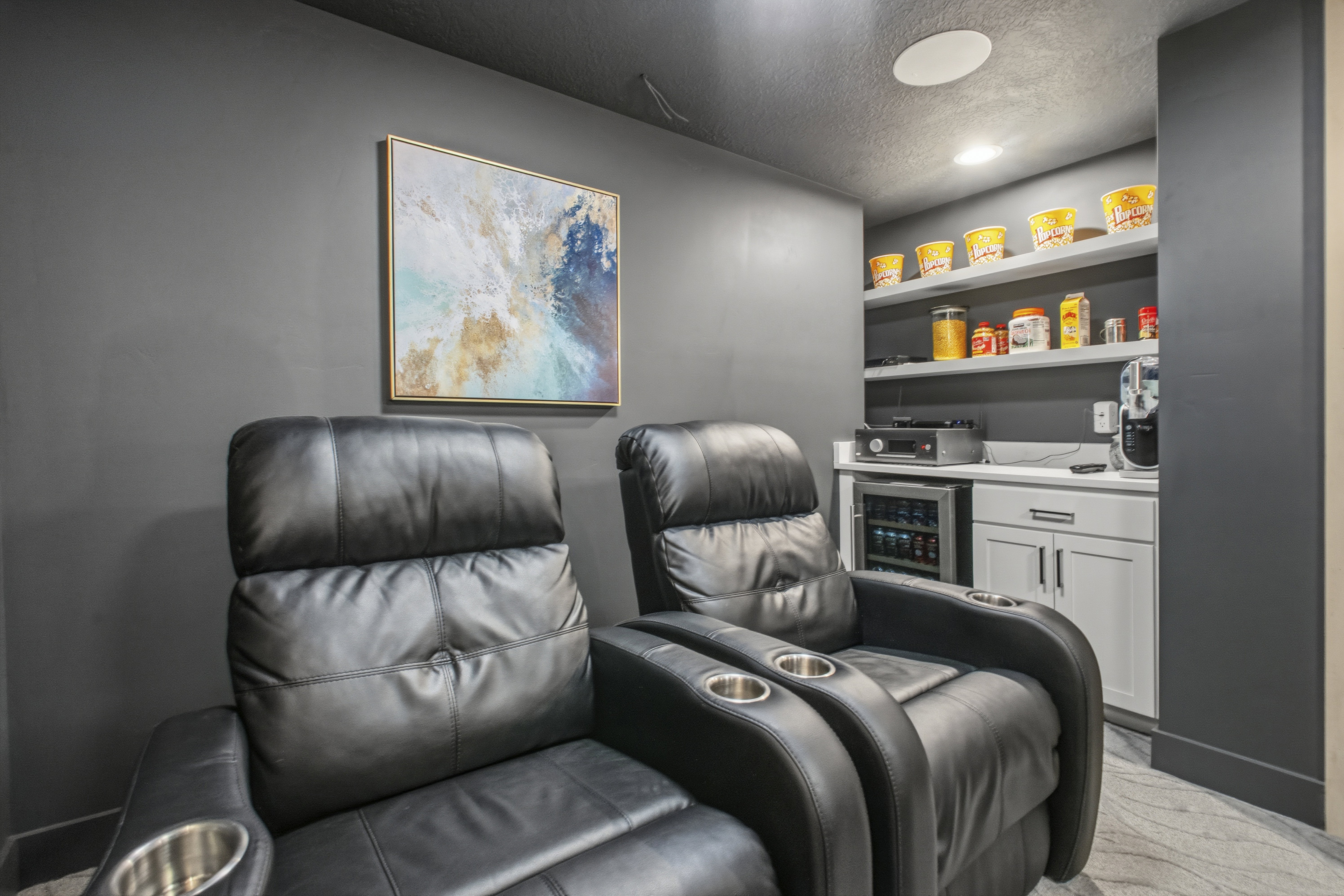 Custom entertainment space featuring black recliners with integrated cup holders