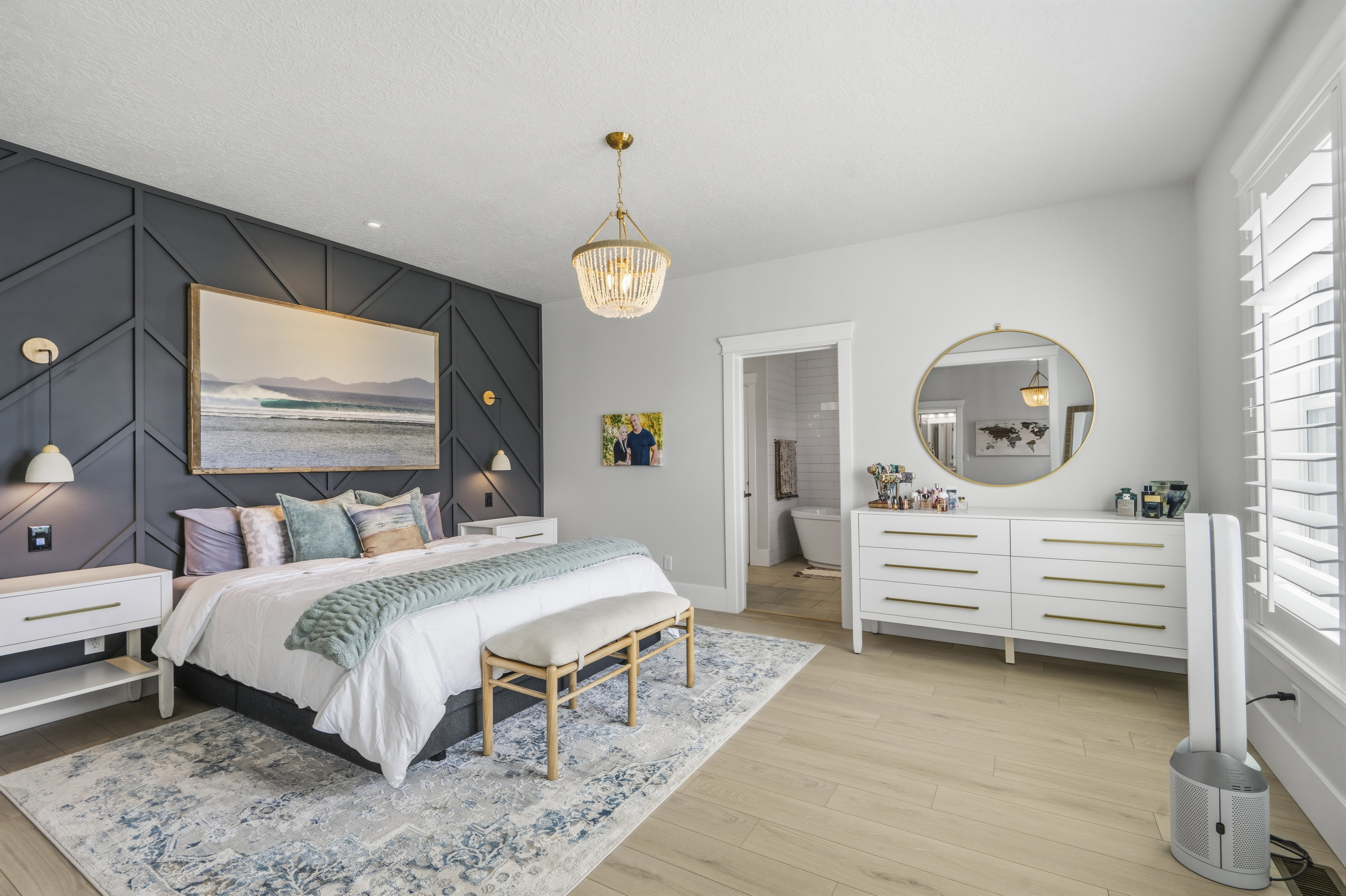 Spacious room featuring a decorative accent wall, wood-finish flooring, and a contemporary chandelier