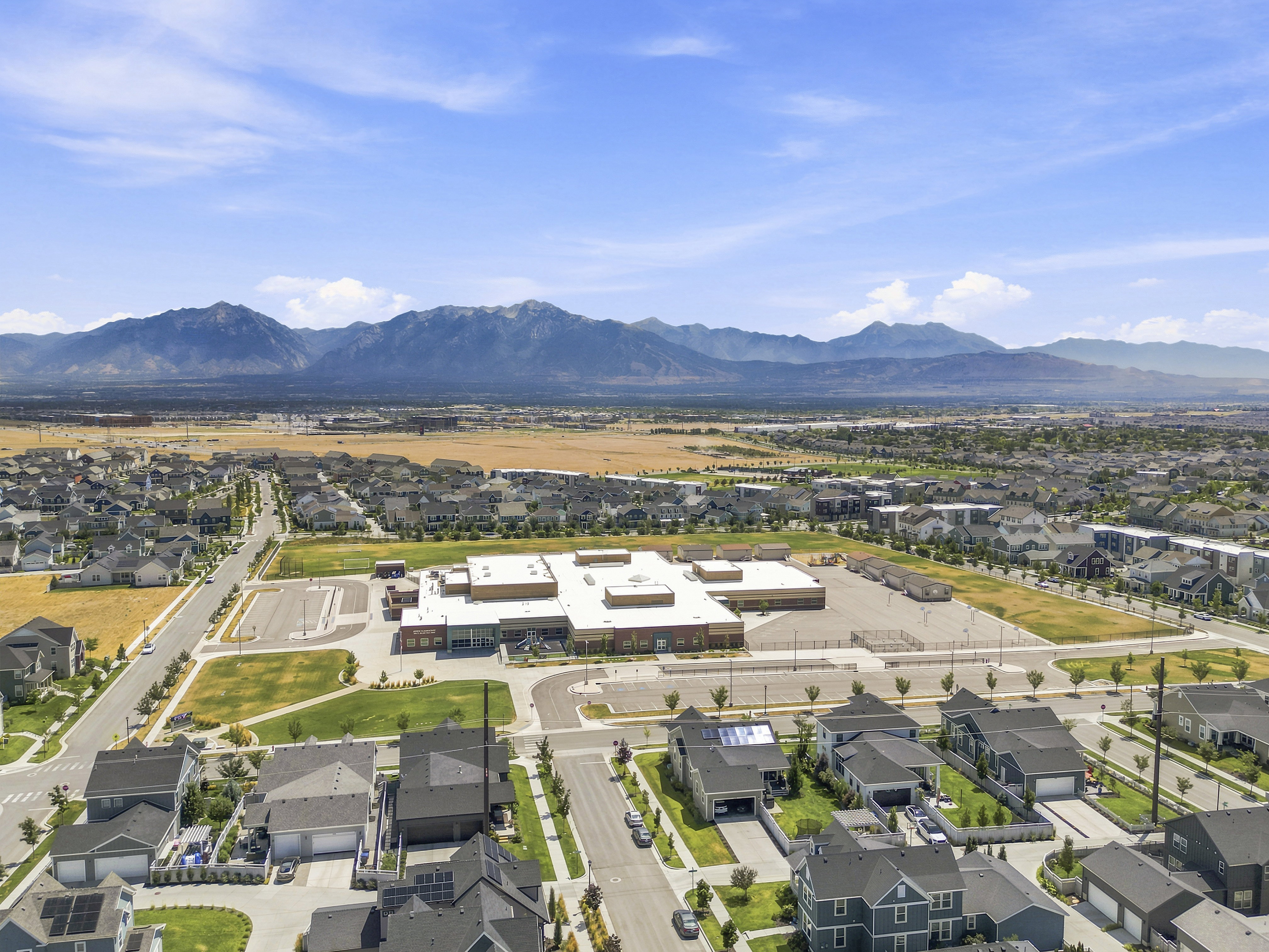 Expansive residential area featuring numerous single-family homes with gray roofs and varied architectural styles