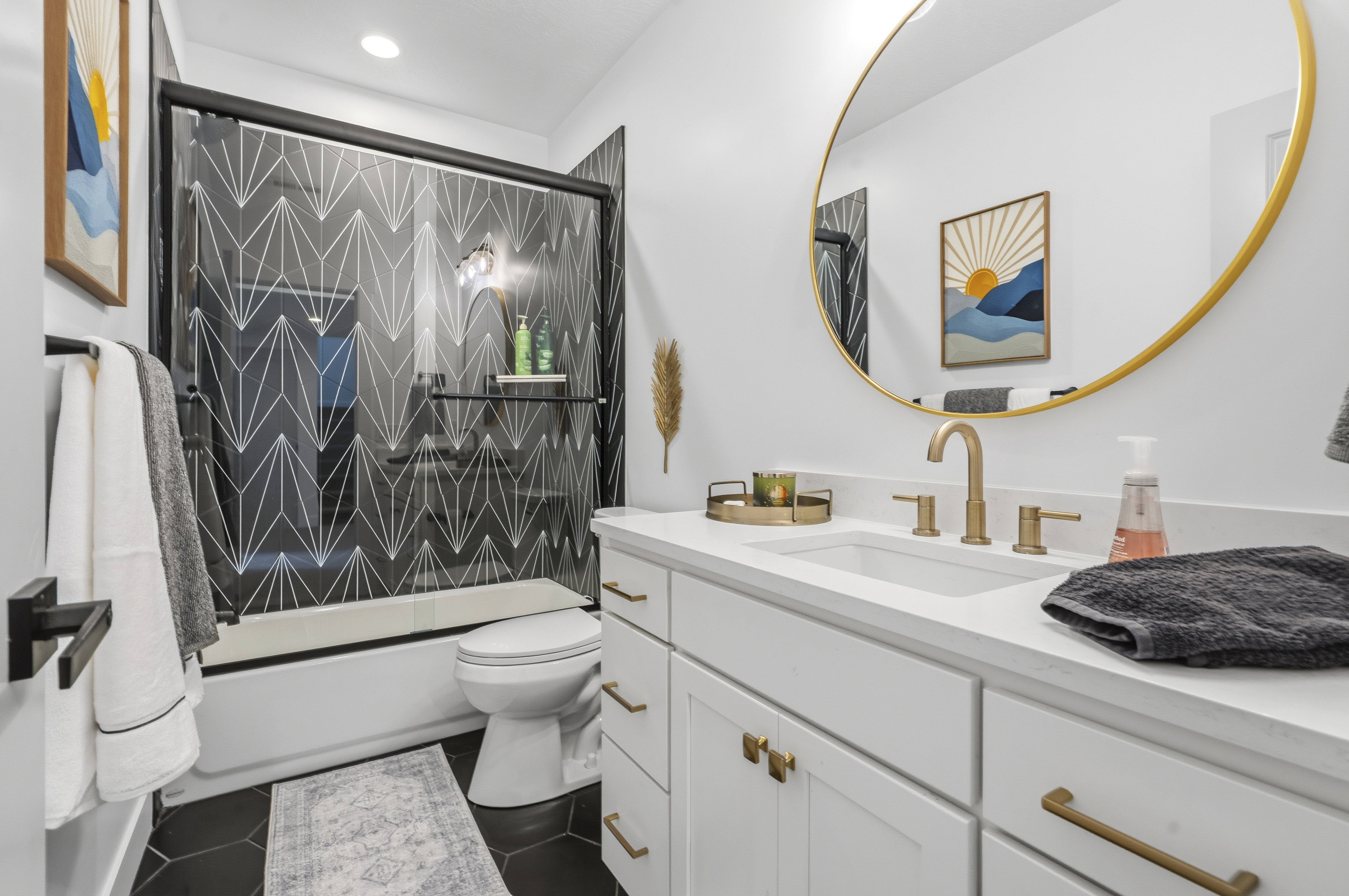 Bathroom featuring a white vanity with gold-tone hardware, a rectangular undermount sink, and a white countertop