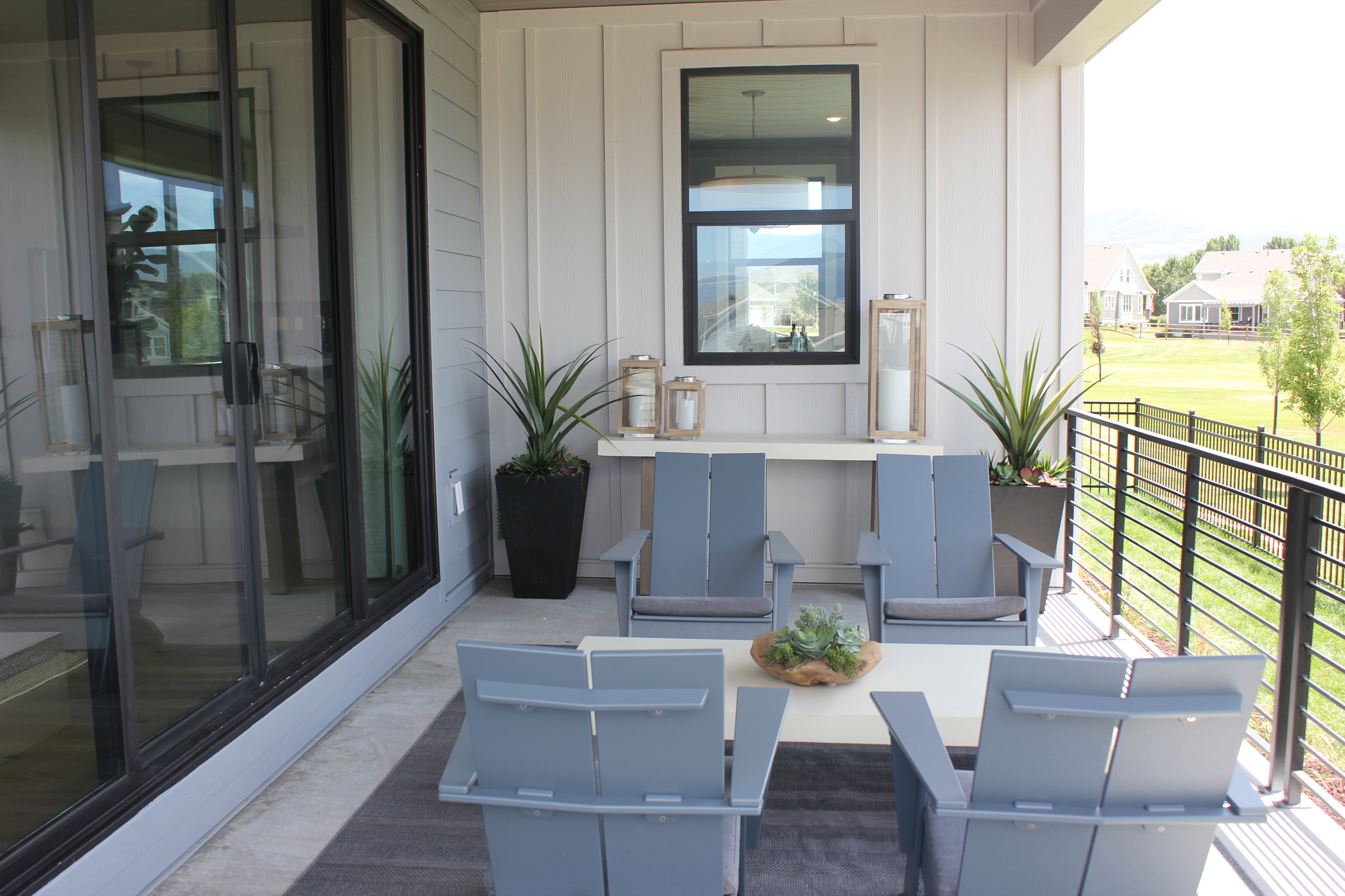 Covered patio featuring a concrete surface, black metal railing, and board-and-batten siding