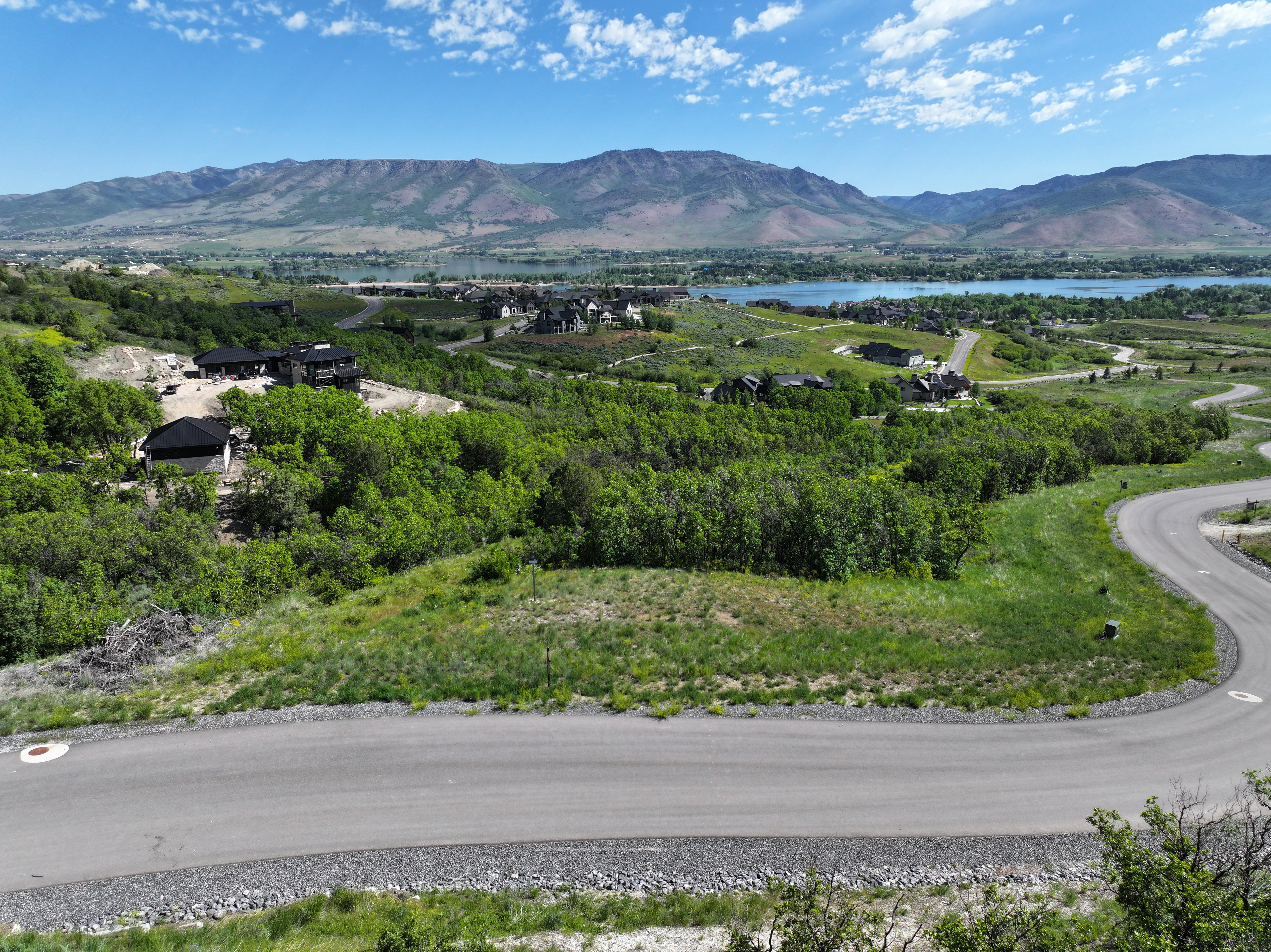Expansive land parcel with surrounding green foliage and distant mountain ranges