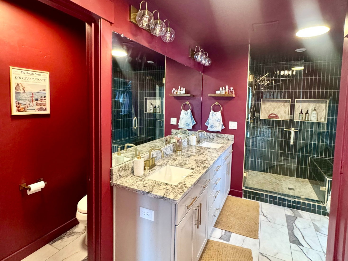 Dual vanity featuring white cabinetry, a light-toned countertop with natural stone patterning, and brass-finish hardware