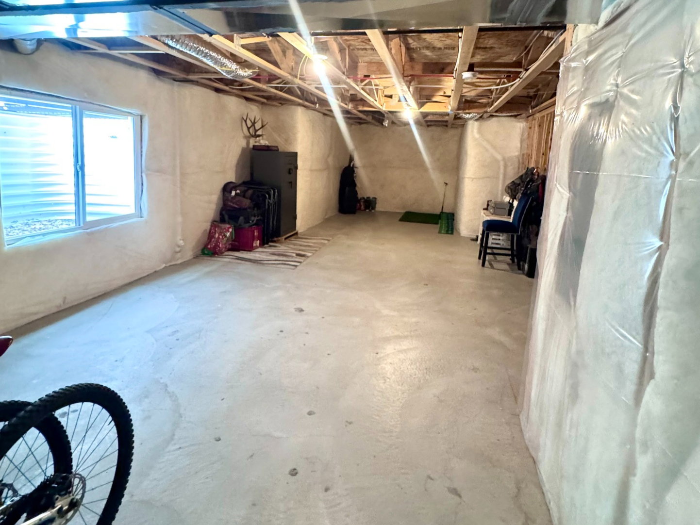 Unfinished basement offering substantial square footage, exposed ceiling joists, and a concrete floor