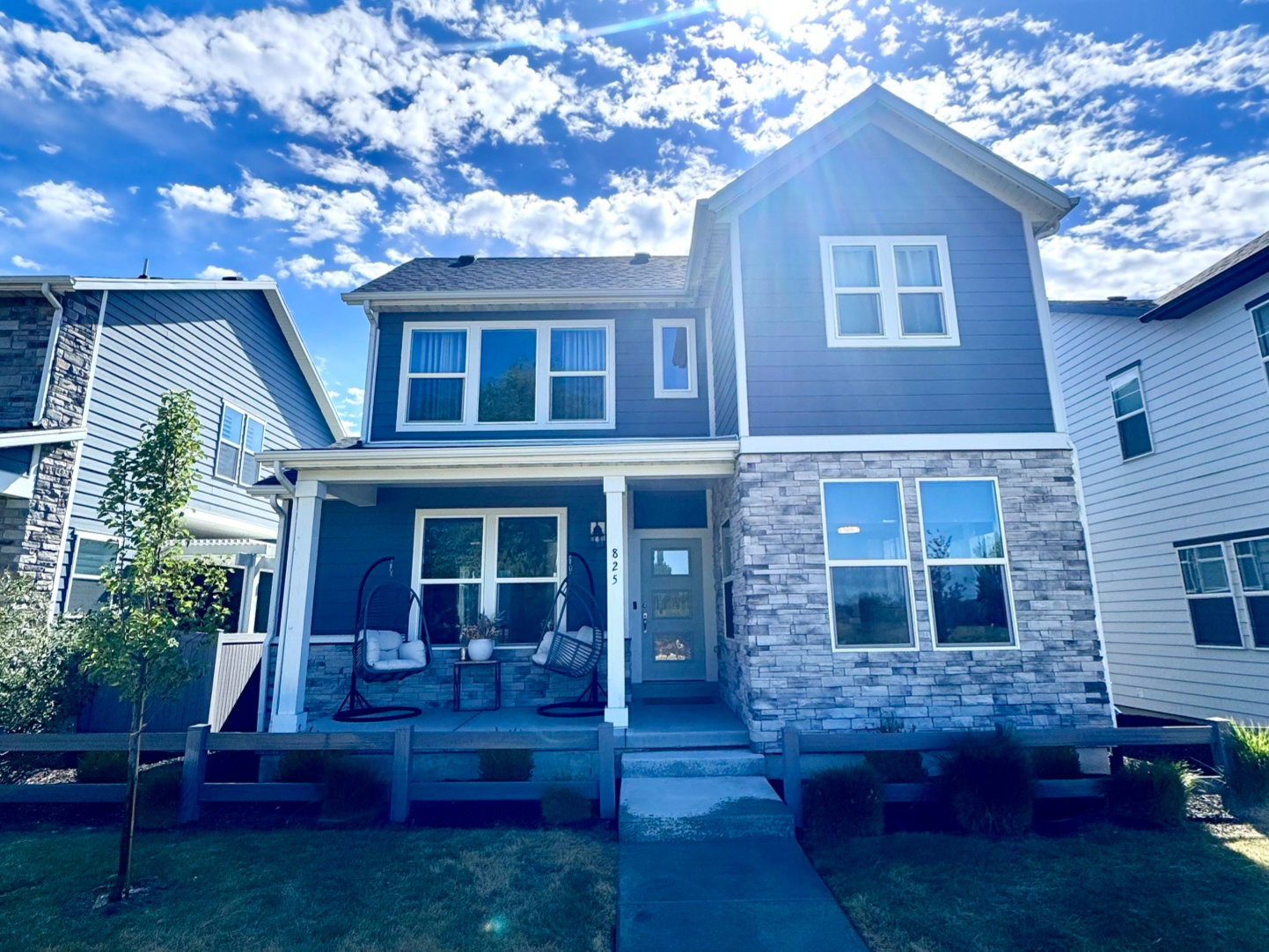 Modern two-story residence featuring a combination of blue horizontal siding and stone veneer
