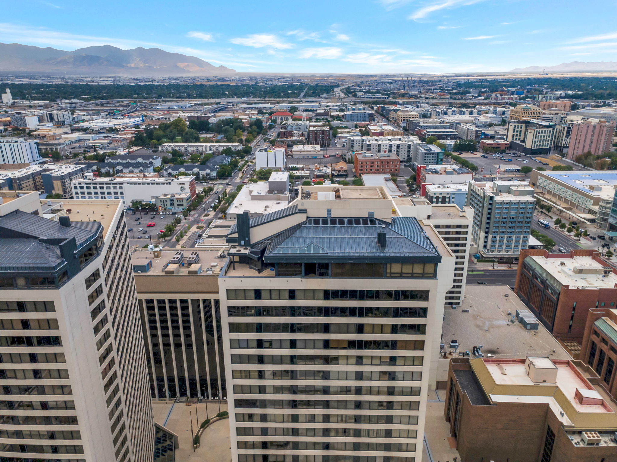 Cityscape featuring multiple high-rise buildings and a distant mountain range
