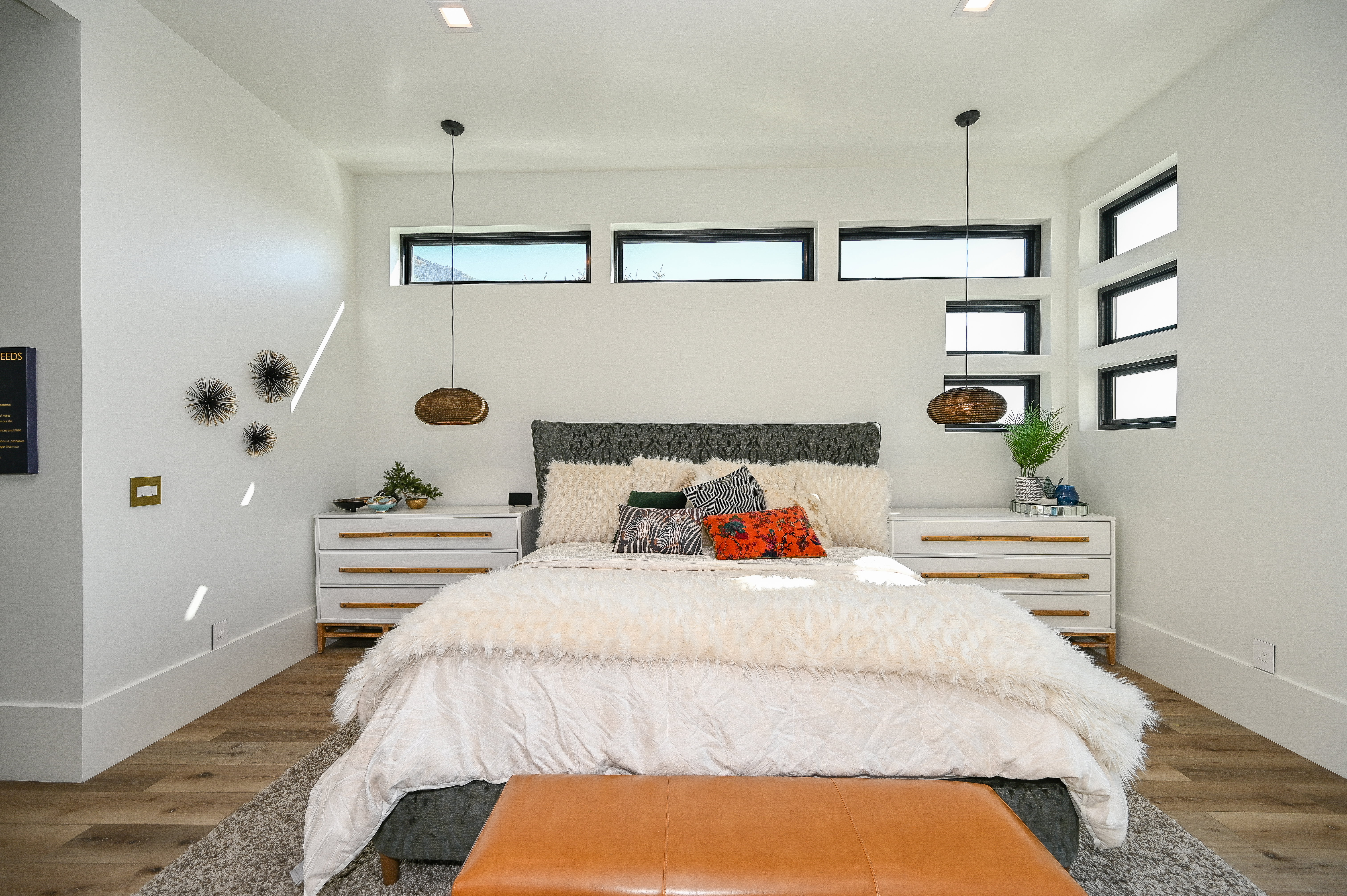 Bedroom featuring high ceilings with recessed lighting, wood-finish flooring, and multiple horizontal and vertical windows with black trim