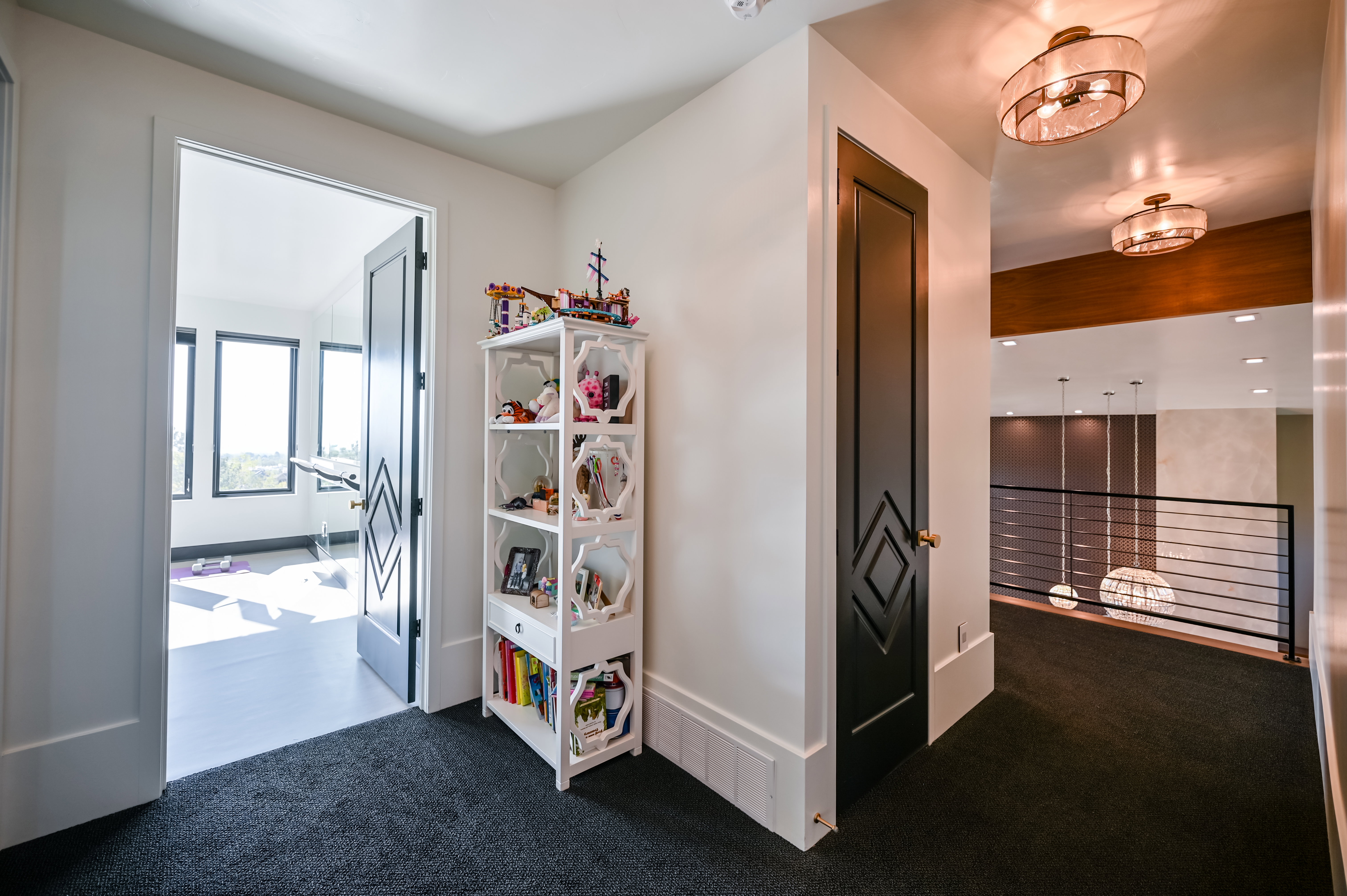 Hallway featuring dark carpeting and a built-in shelving unit