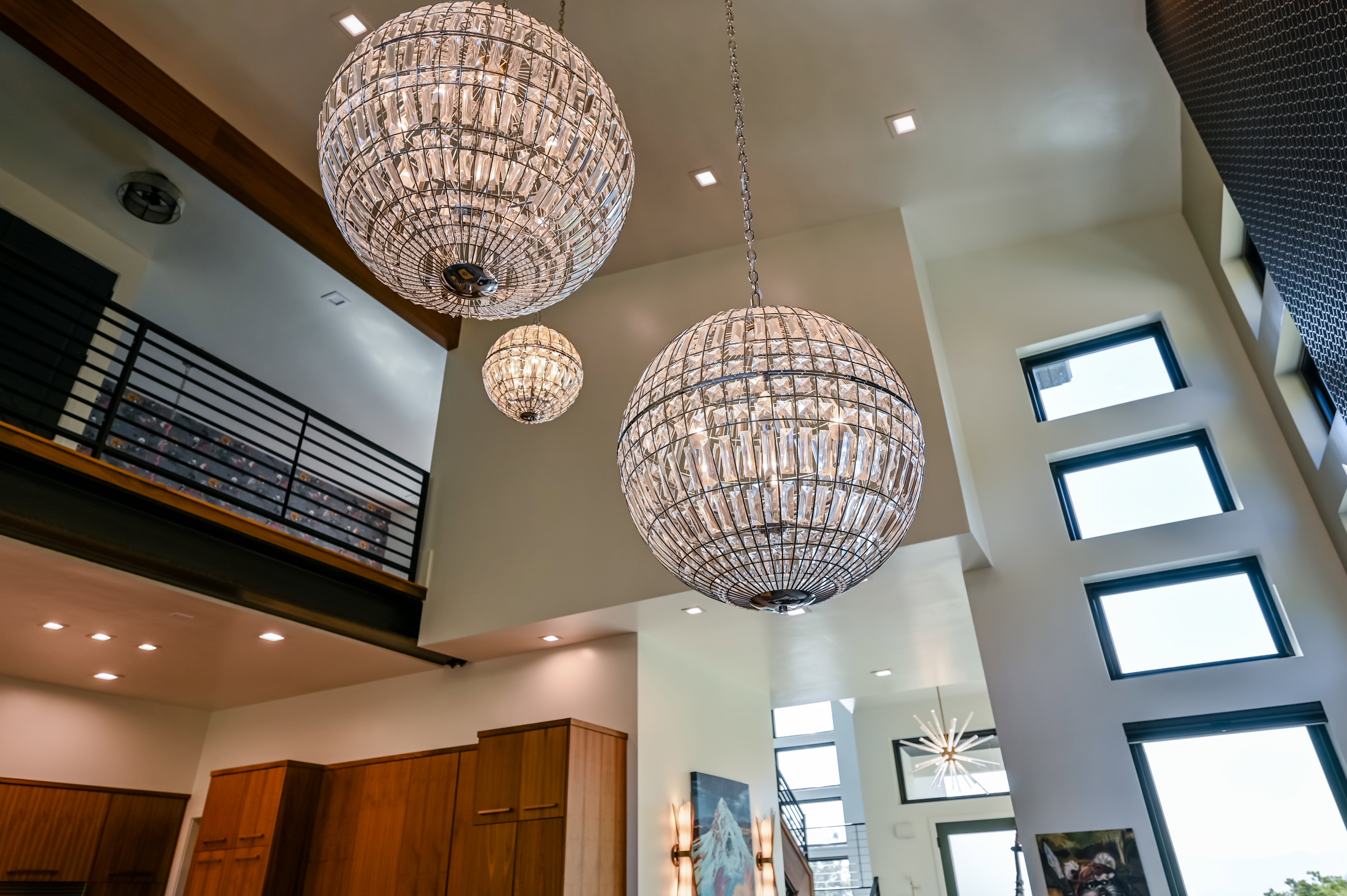 Double-height ceilings featuring three spherical crystal chandeliers