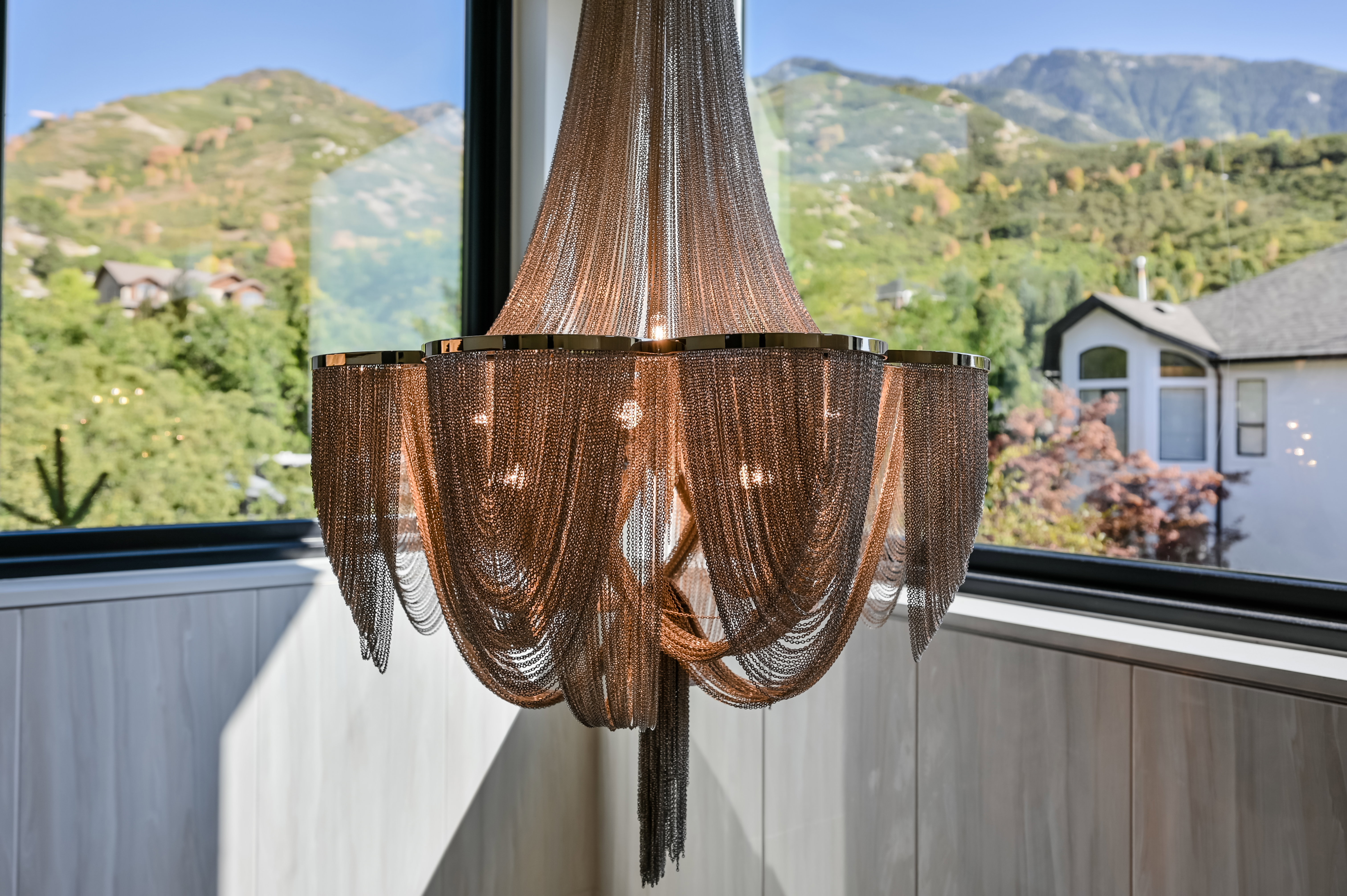 Contemporary chandelier with draped chain detailing and gold-tone accents