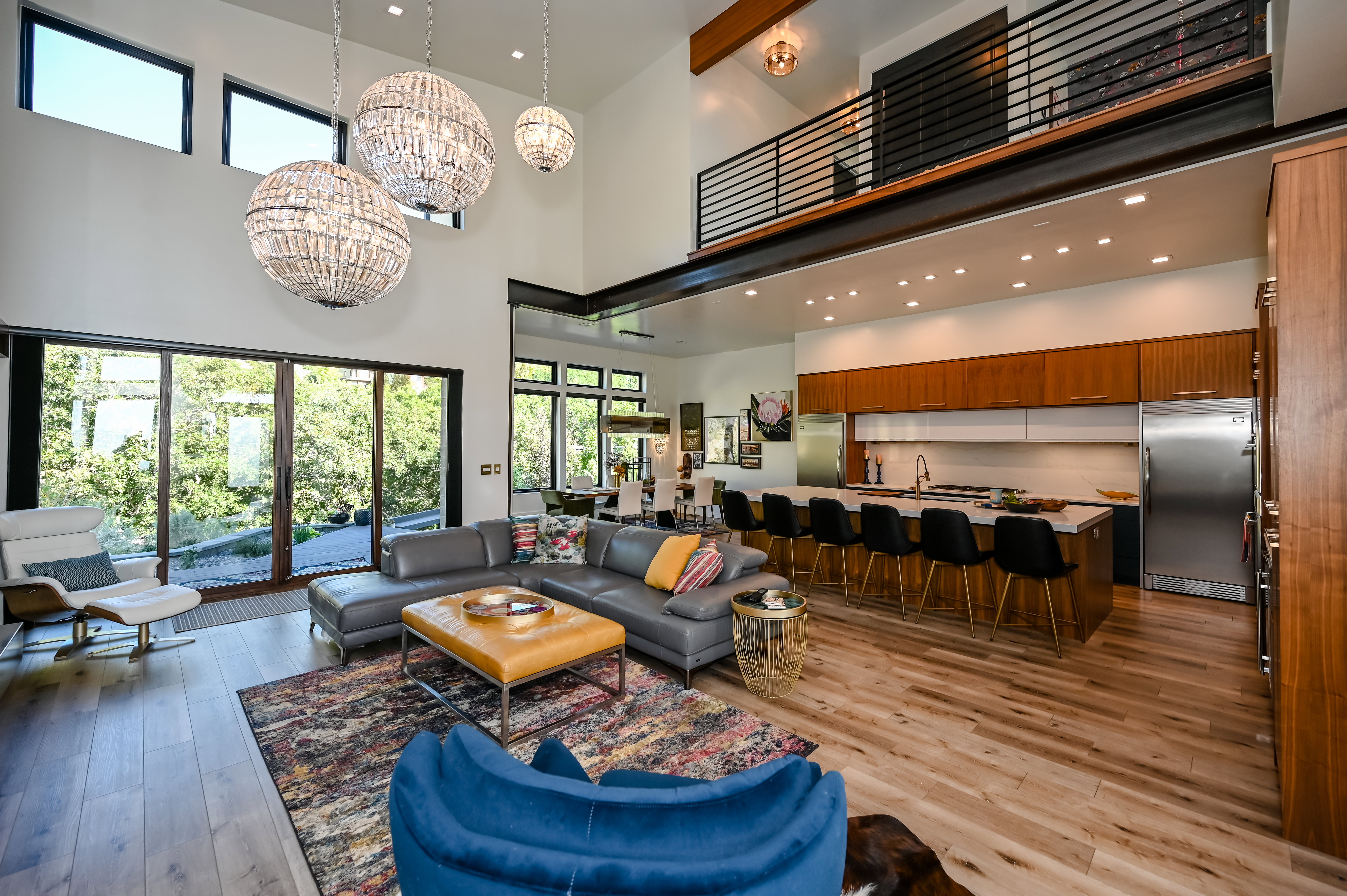 Open-concept living space featuring high ceilings, wood-finish flooring, and large sliding glass doors