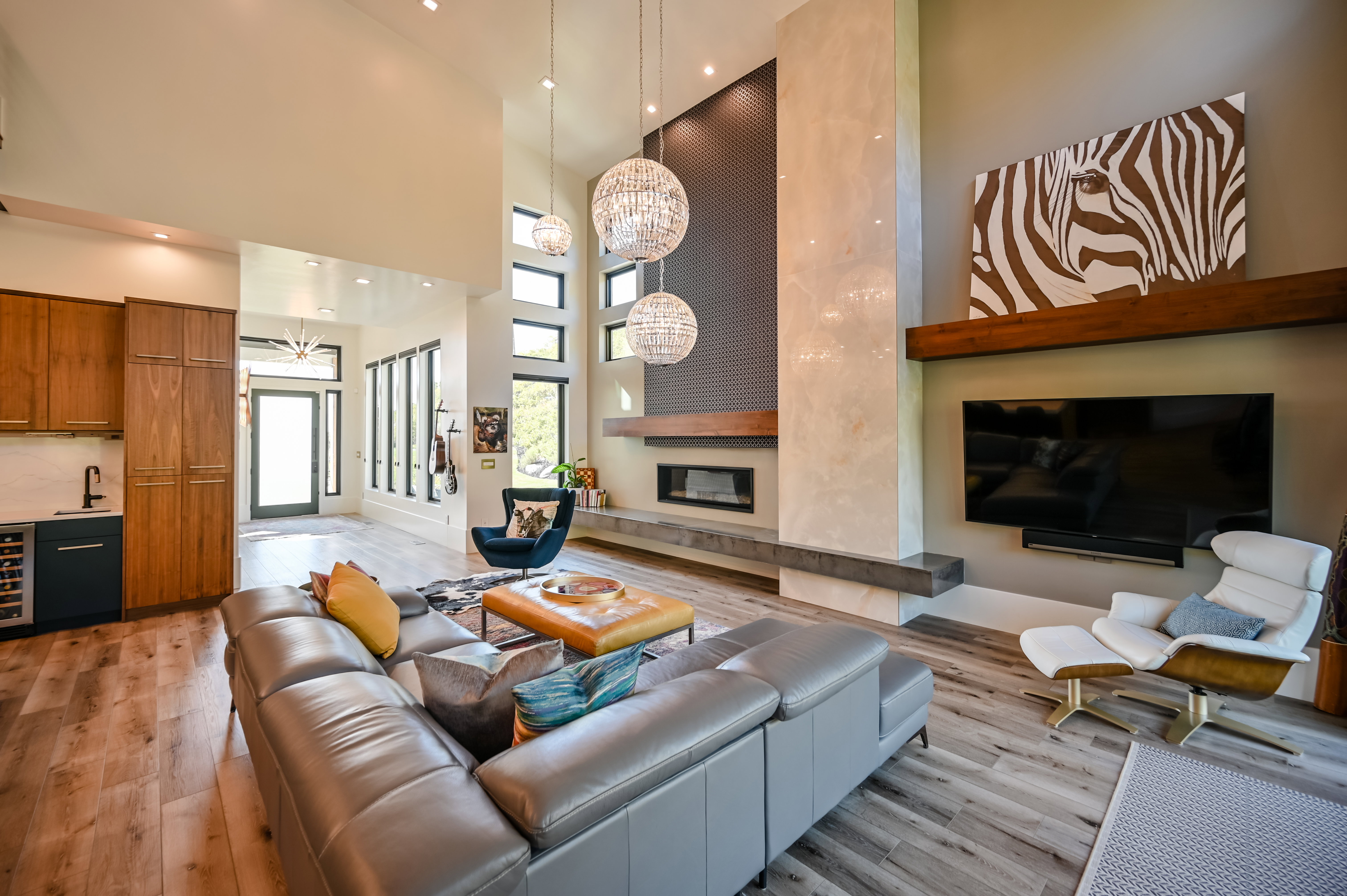 Open-concept living area with a double-height ceiling and wood-finish flooring