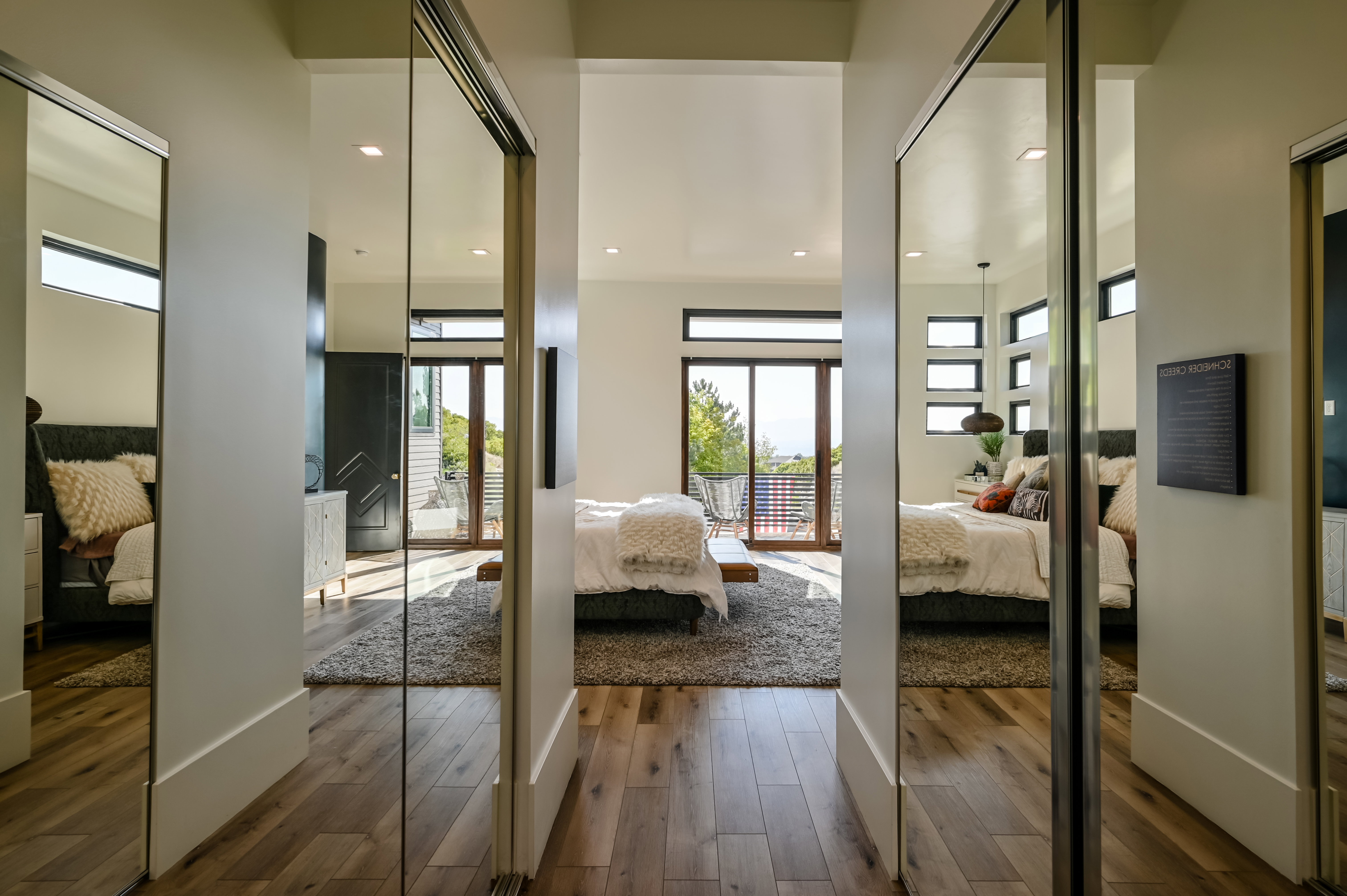 Hallway with wood-finish flooring, recessed lighting, and mirrored closet doors
