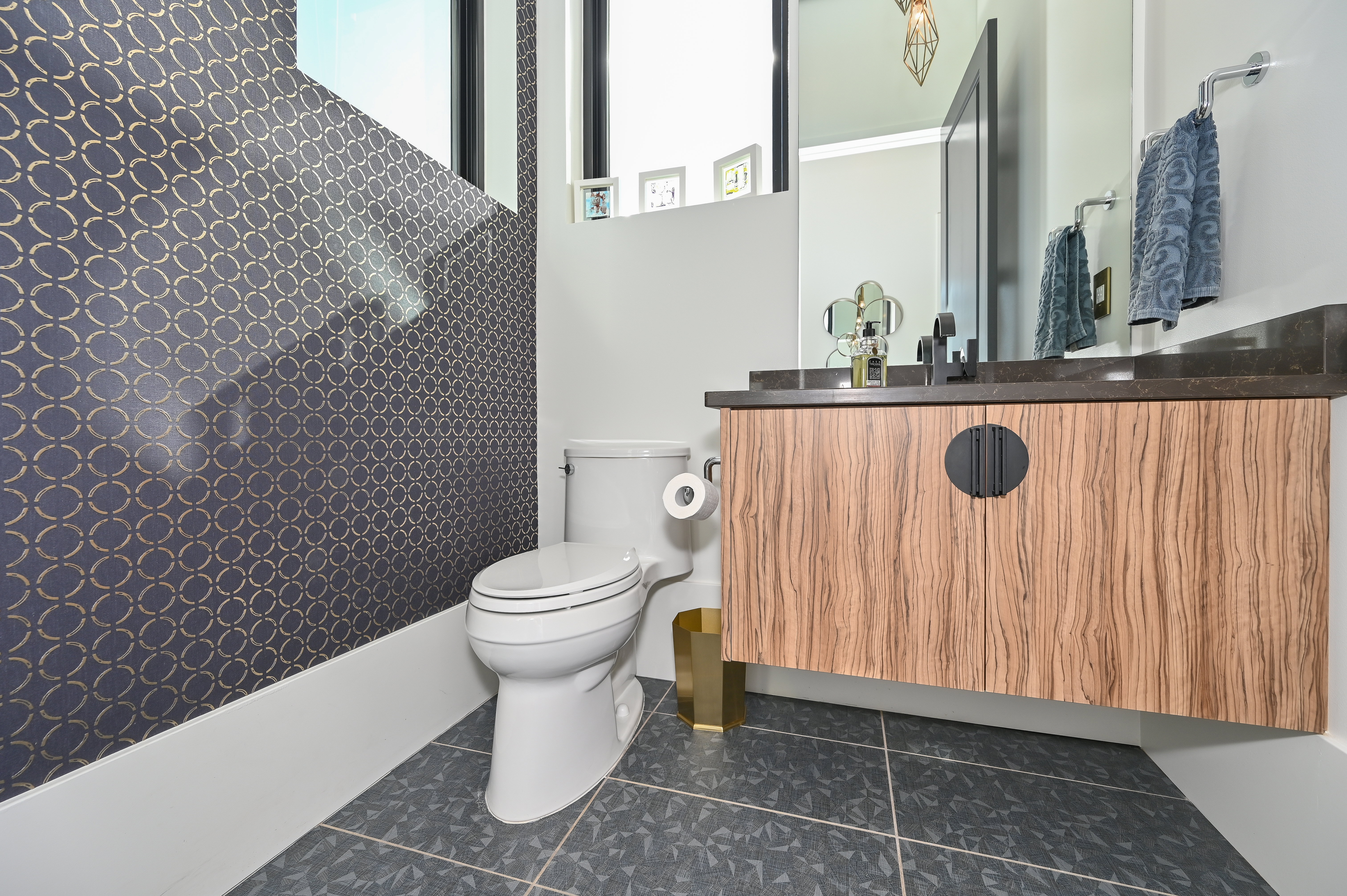 Powder room featuring a floating wood-finish vanity with a dark countertop and matte black faucet