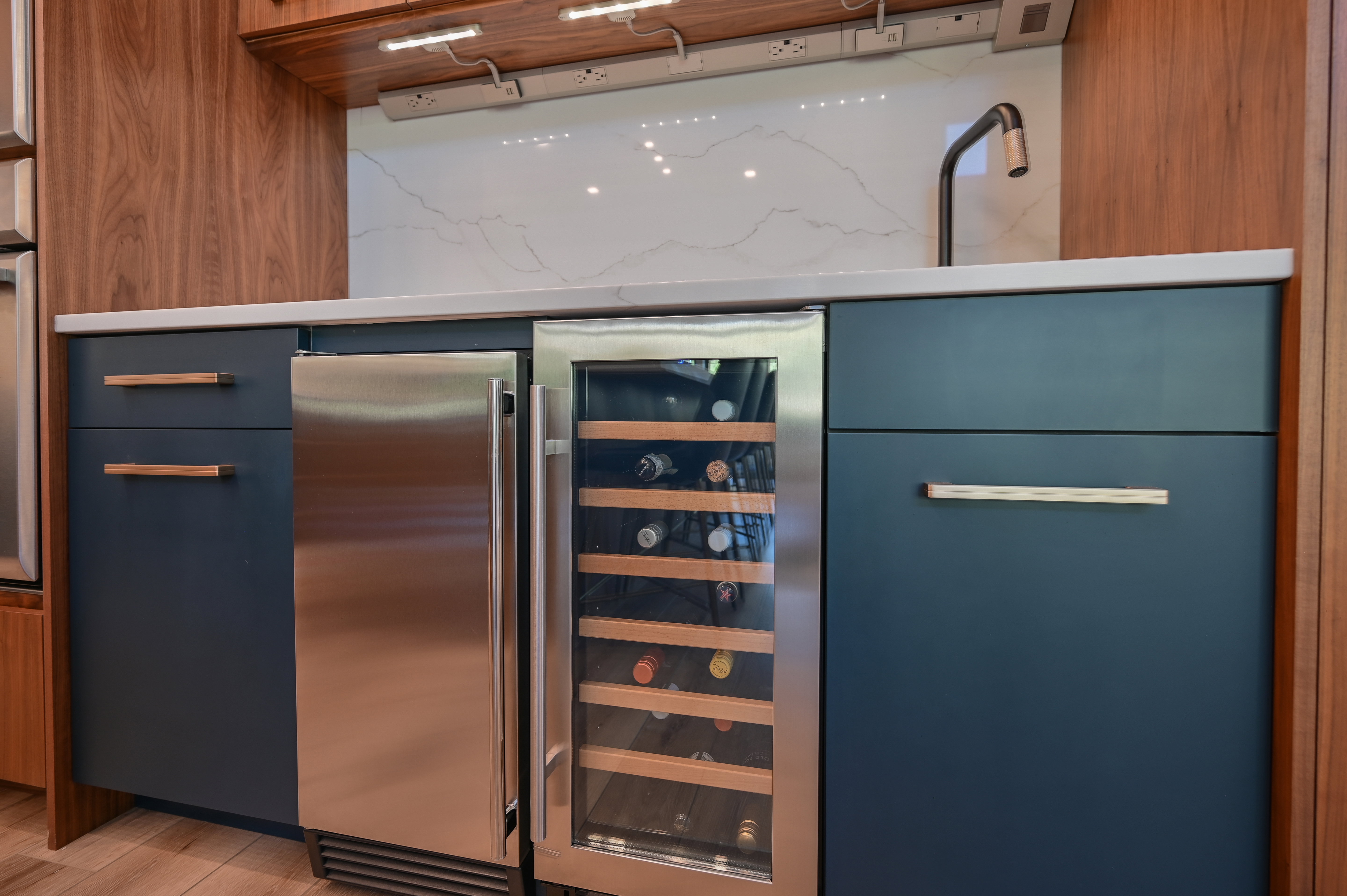 Wet bar featuring navy cabinetry, a stainless steel beverage refrigerator, and a built-in wine cooler