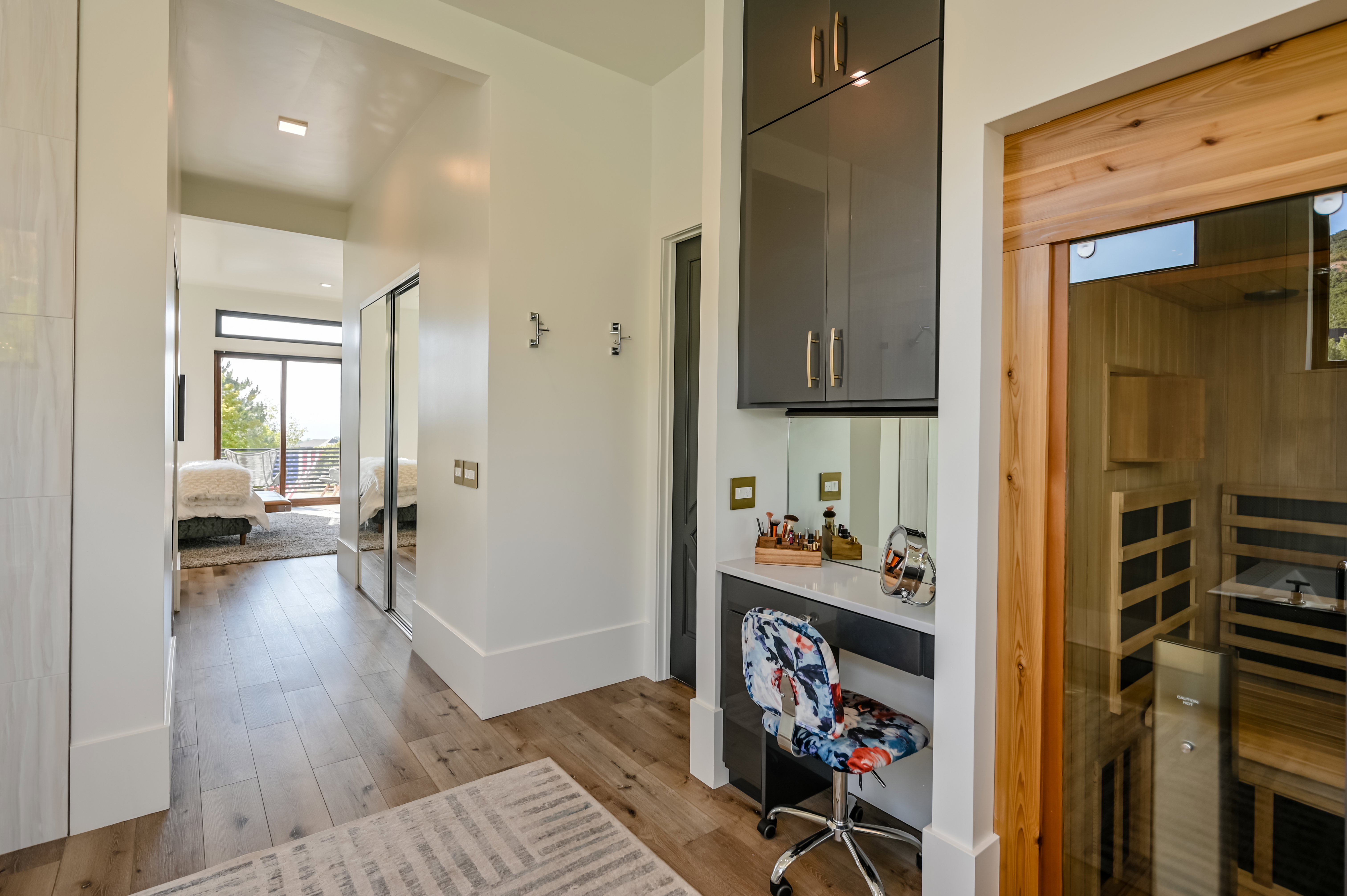 Light wood-finish flooring extending through a hallway with white walls